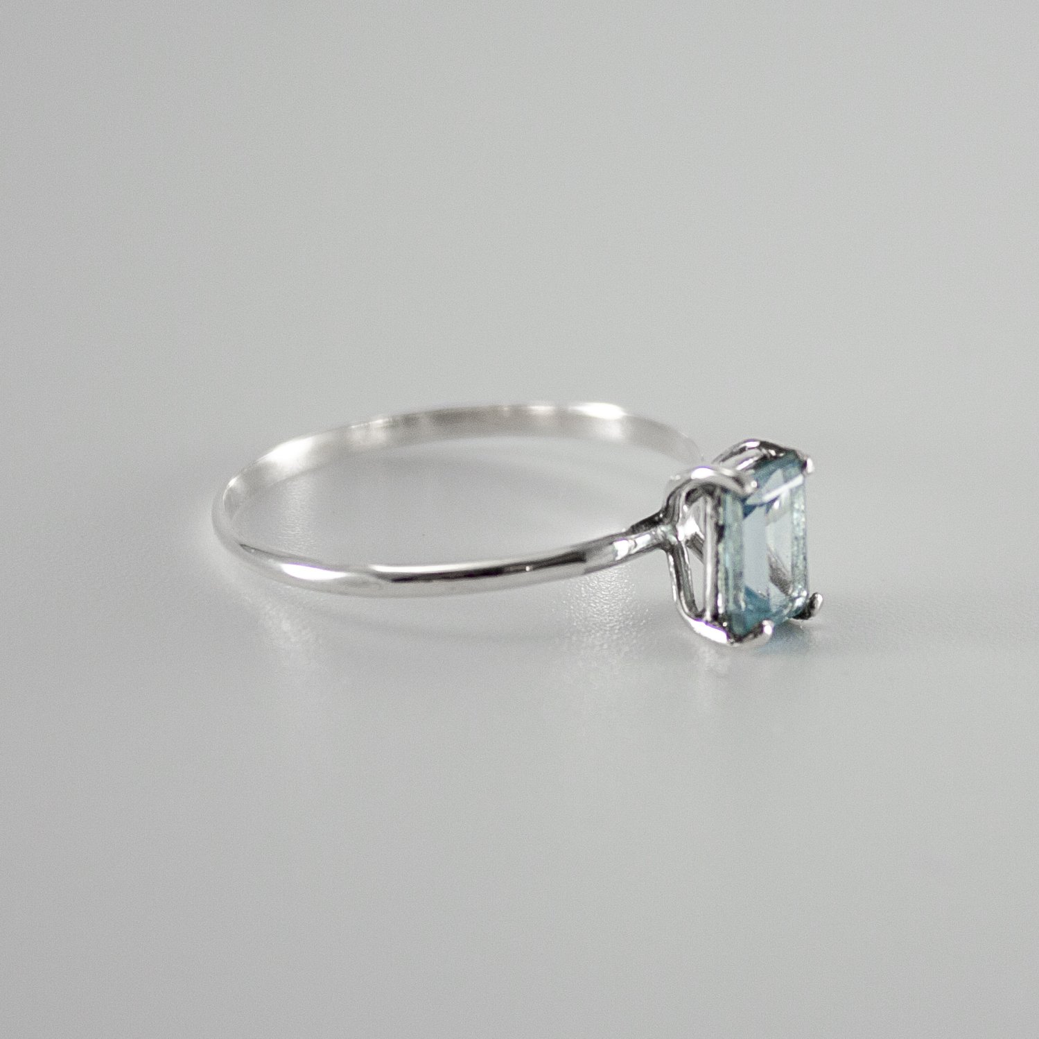 Sky Blue Topaz Four Prong Solitaire Ring in sterling silver, showcasing a vibrant blue gemstone set in a delicate band.