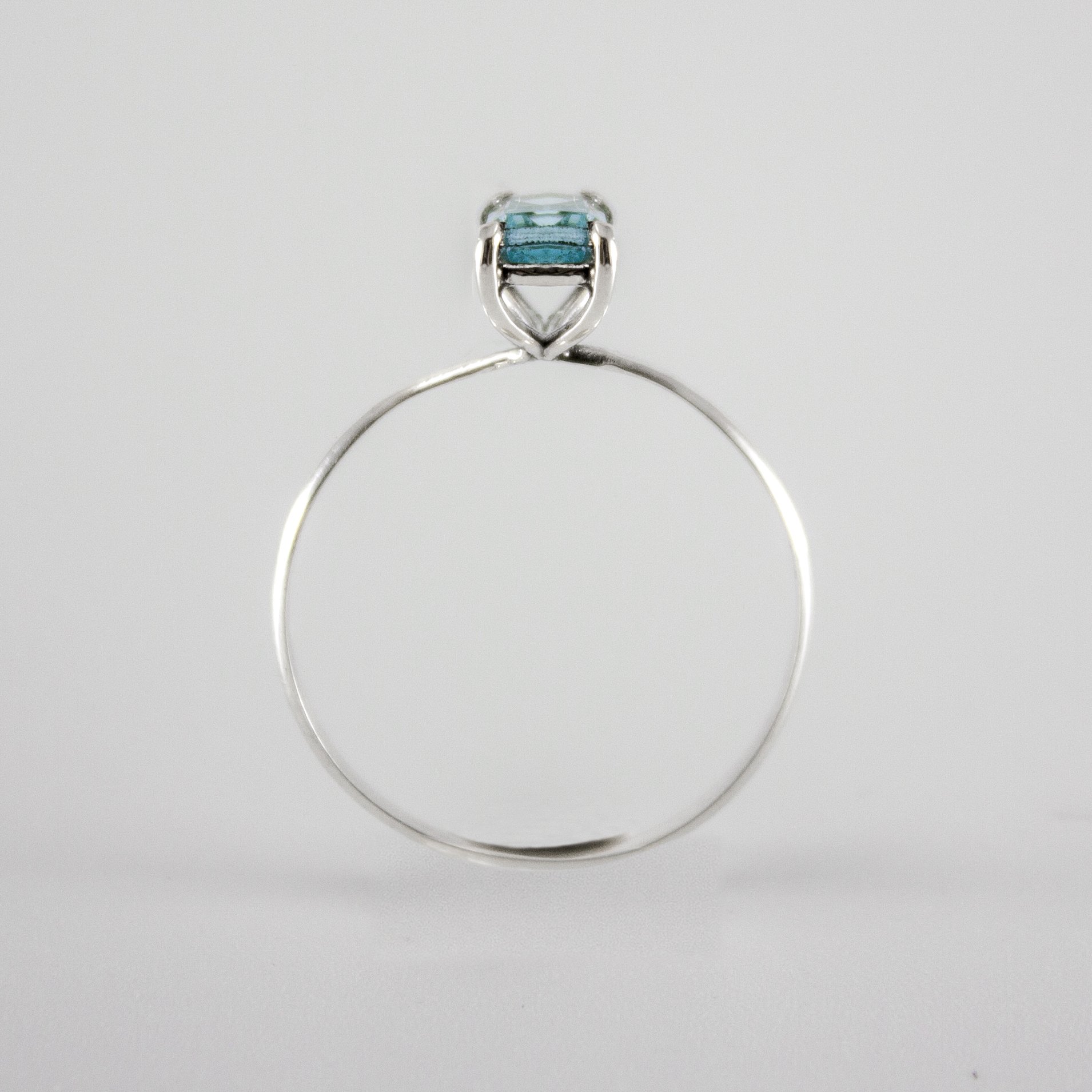 Sky Blue Topaz Four Prong Solitaire Ring in sterling silver, showcasing a vibrant blue gemstone set in a delicate band.