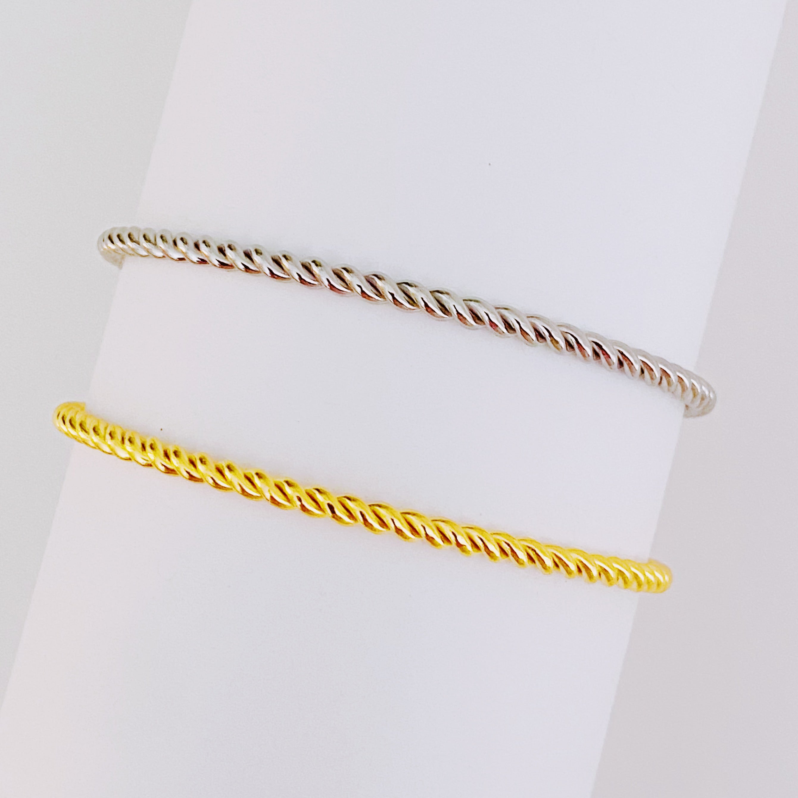 Slim and cabled open bangle bracelet with sparkly stones, showcasing a flexible design and elegant gold finish.