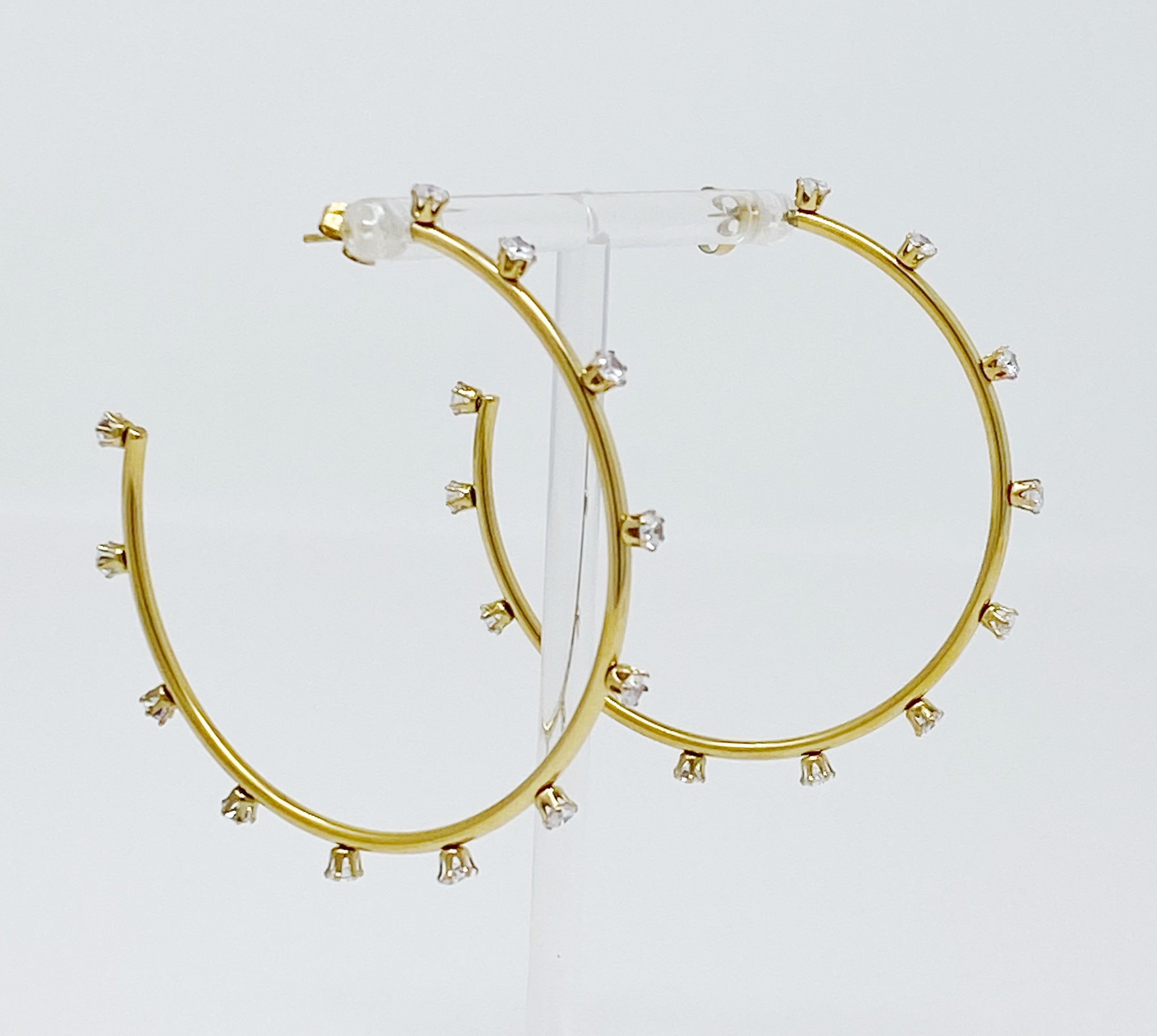 A pair of slim gold plated hoop earrings adorned with sparkling cubic zirconia jewels, showcasing elegance and style.