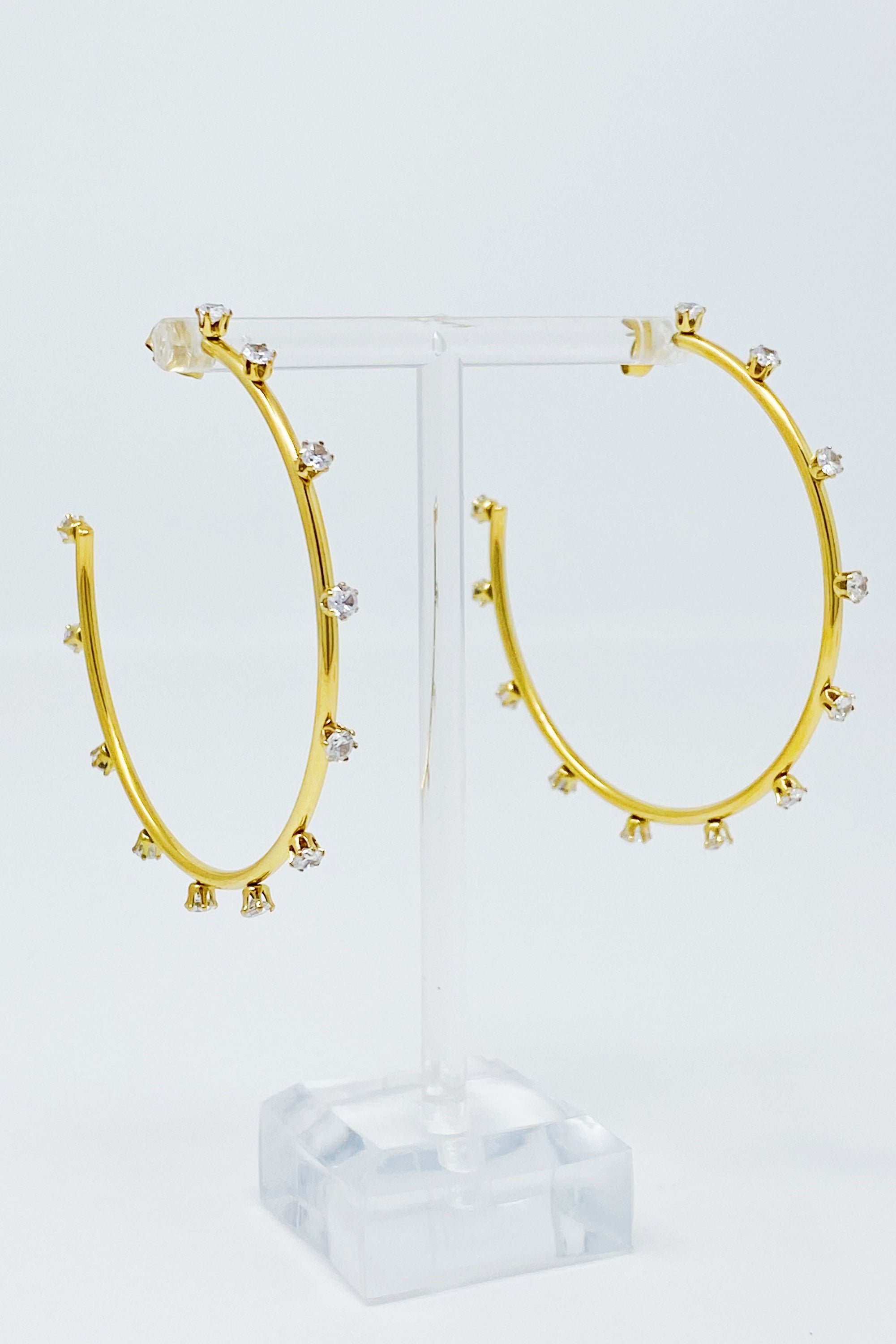 A pair of slim gold plated hoop earrings adorned with sparkling cubic zirconia jewels, showcasing elegance and style.