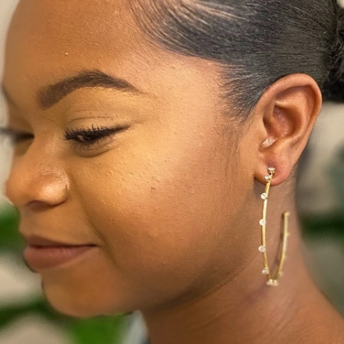 A pair of slim gold plated hoop earrings adorned with sparkling cubic zirconia jewels, showcasing elegance and style.