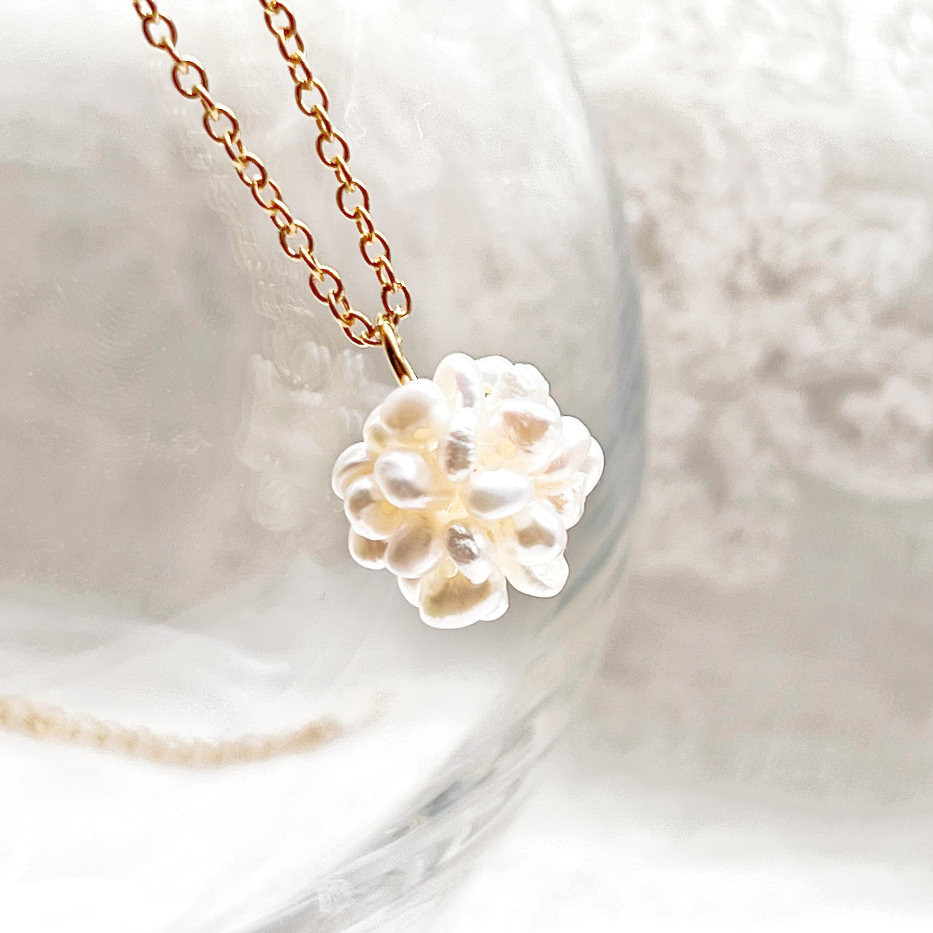 A delicate Small Freshwater Pearl Globe Necklace featuring baroque pearls on a gold-plated chain, elegantly displayed in a gift box.