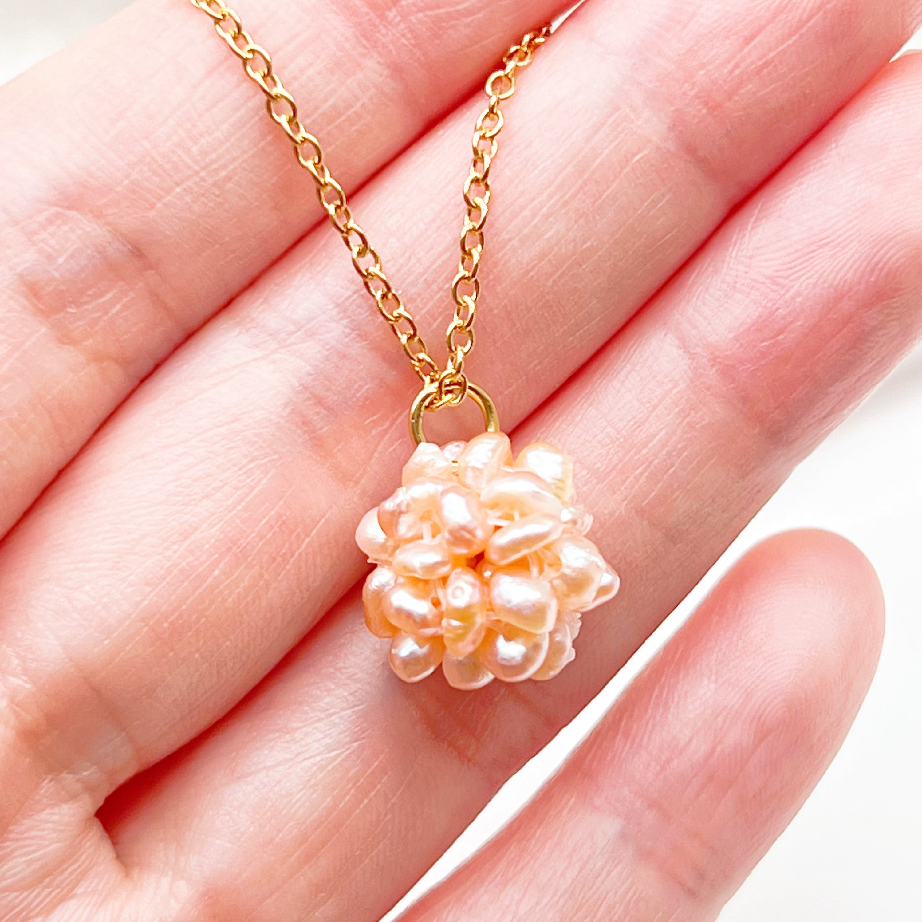 A delicate Small Pink Freshwater Pearl Globe Necklace featuring baroque pearls shaped into a globe, with a gold-plated chain.