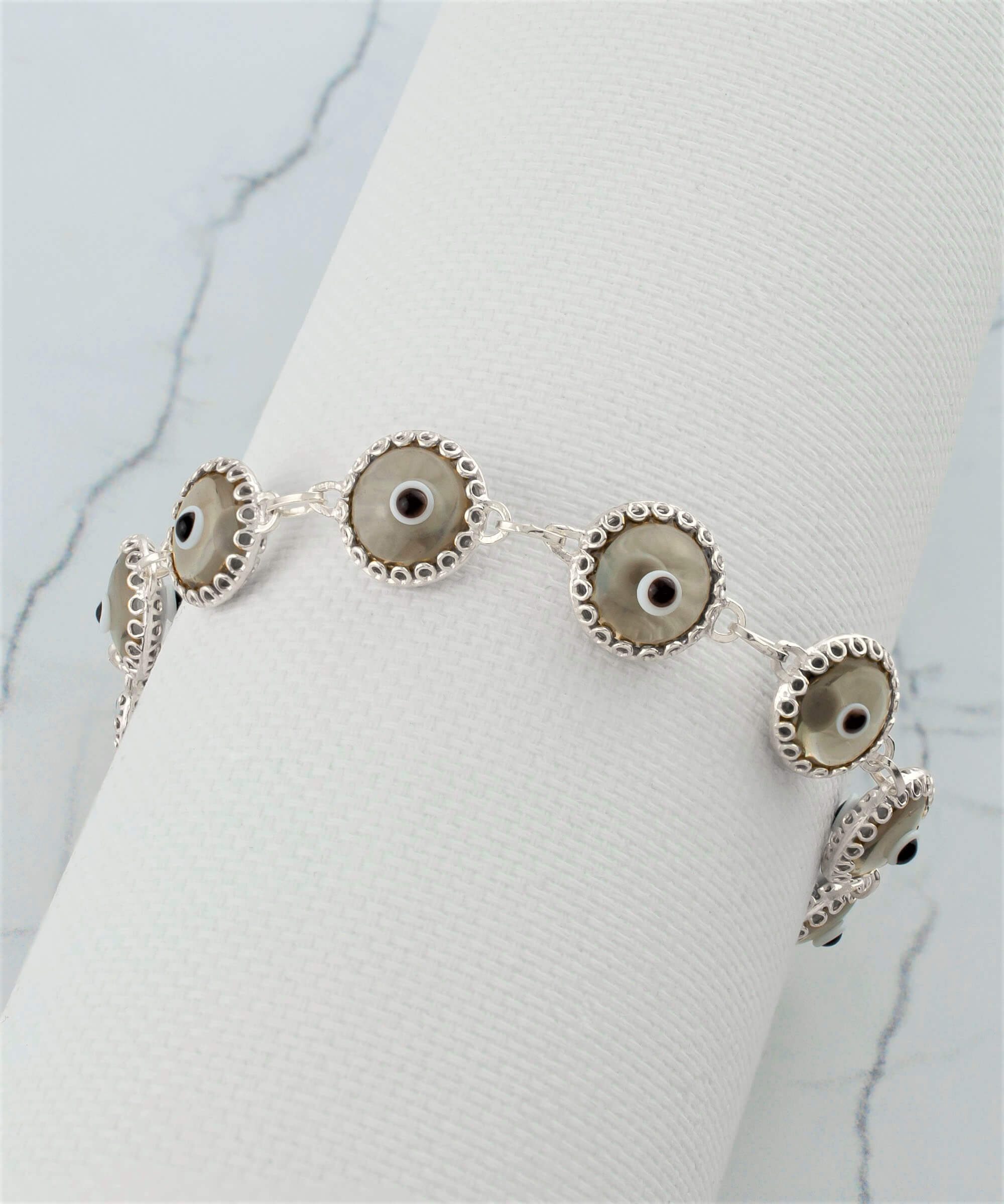 Smokey Evil Eye Woman Sterling Silver Adjustable Link Bracelet featuring a strong rolo chain and ten beads wrapped in silver prongs.