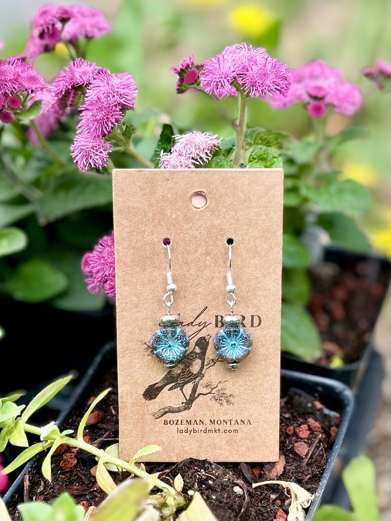 Smoky blue Czech glass hibiscus flower earrings with blue etching, showcasing a delicate floral design.