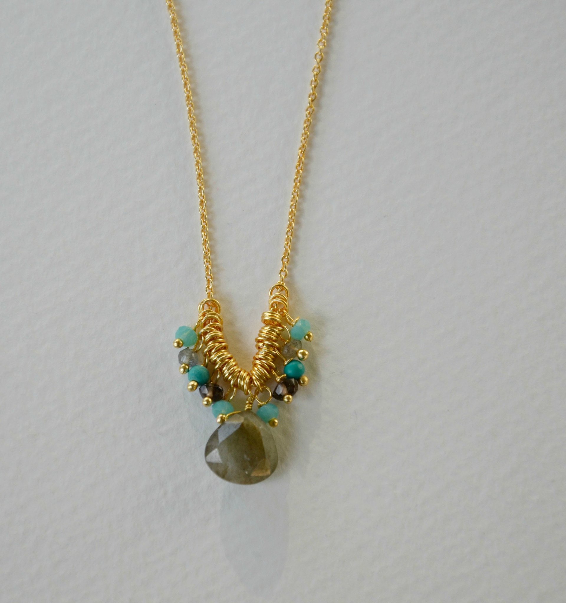 A beautiful Smoky Quartz Drop Necklace featuring a smoky quartz drop and aquamarine petite beads on an 18-inch gold chain.