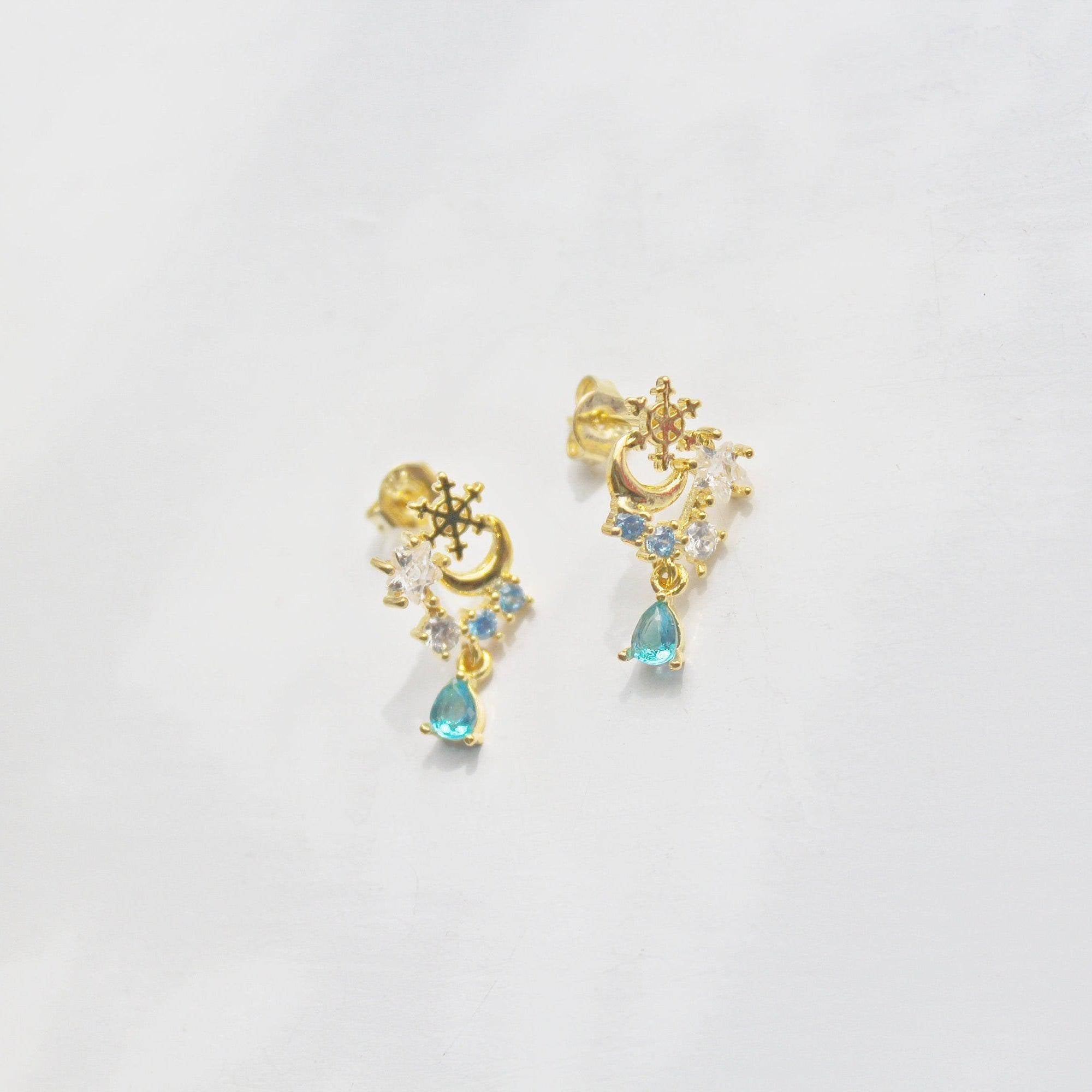 Elegant snowflake and blue crystal earrings in mini teardrop design, showcasing gold plated bronze and sterling silver materials.