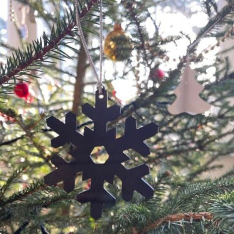 Handcrafted snowflake decoration made from reclaimed inner tube, showcasing unique patterns and eco-friendly design.