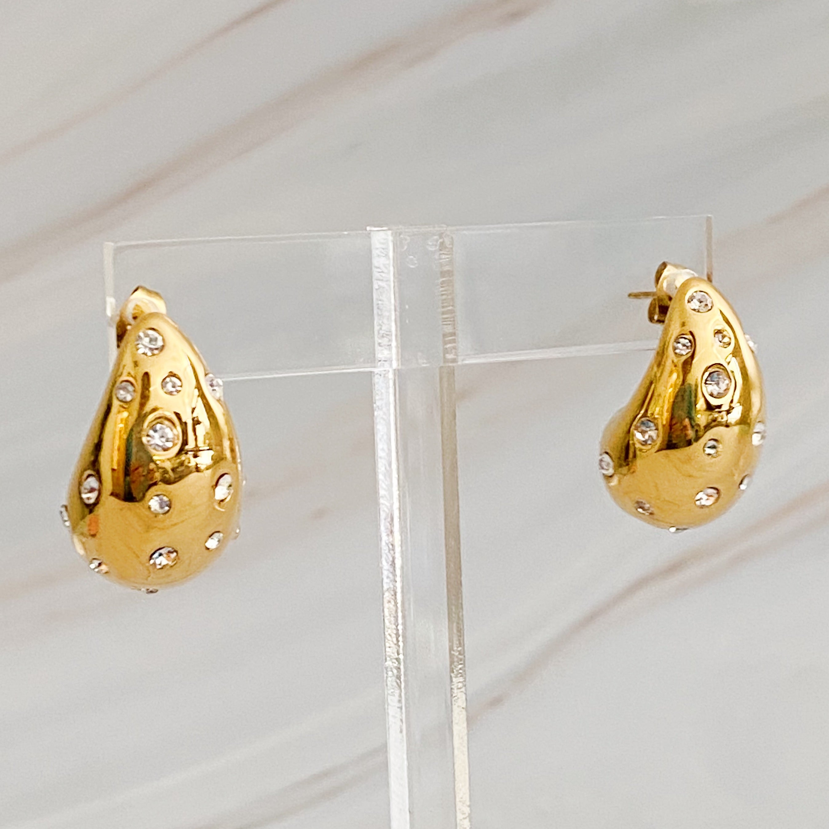 So Chic Jeweled Teardrop Earrings featuring a luxurious teardrop shape with sparkling stones, crafted from 18k gold plated stainless steel.