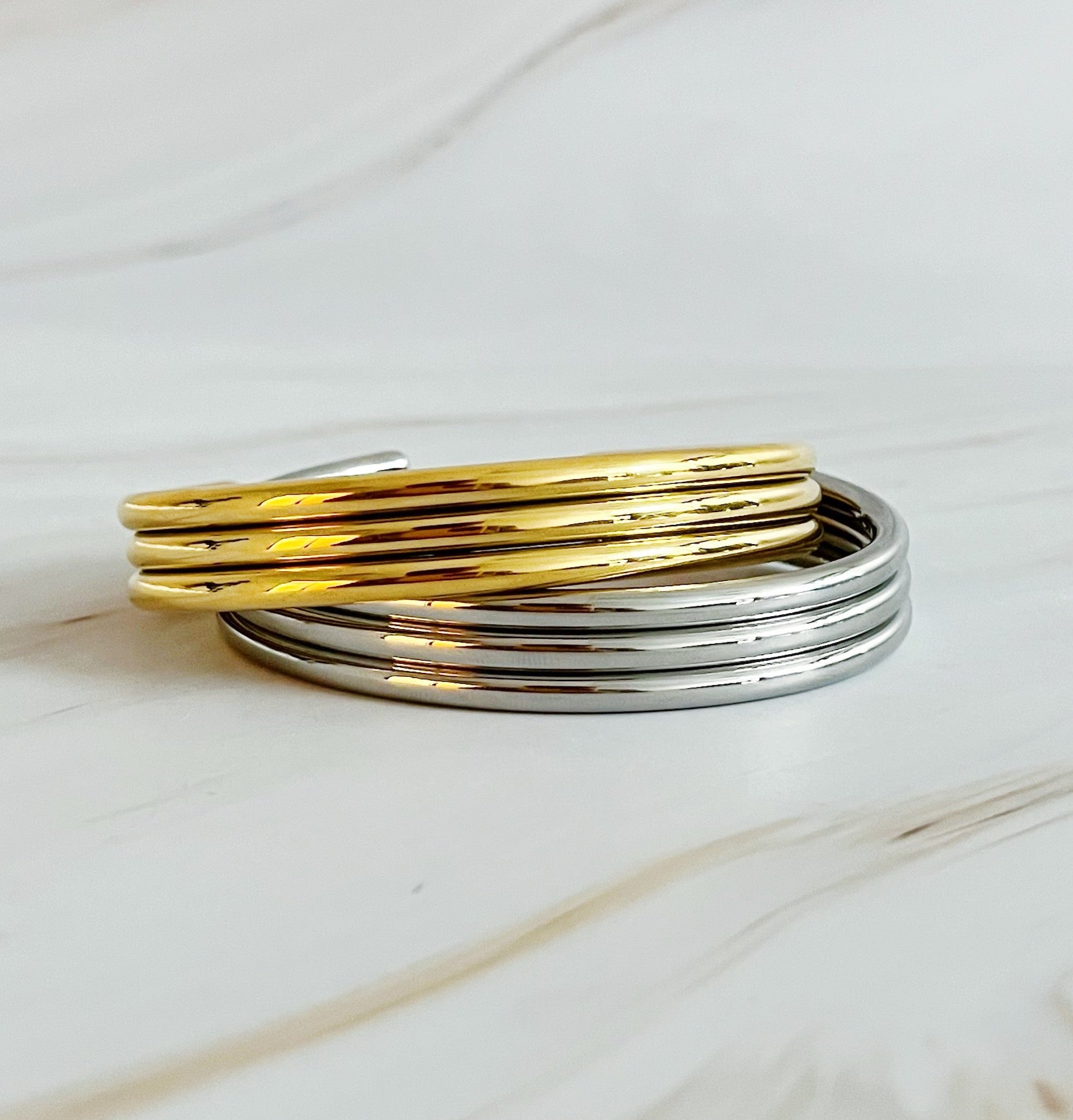 Elegant So Chic Open Bangle in 18k gold plated stainless steel with a unique twist design.