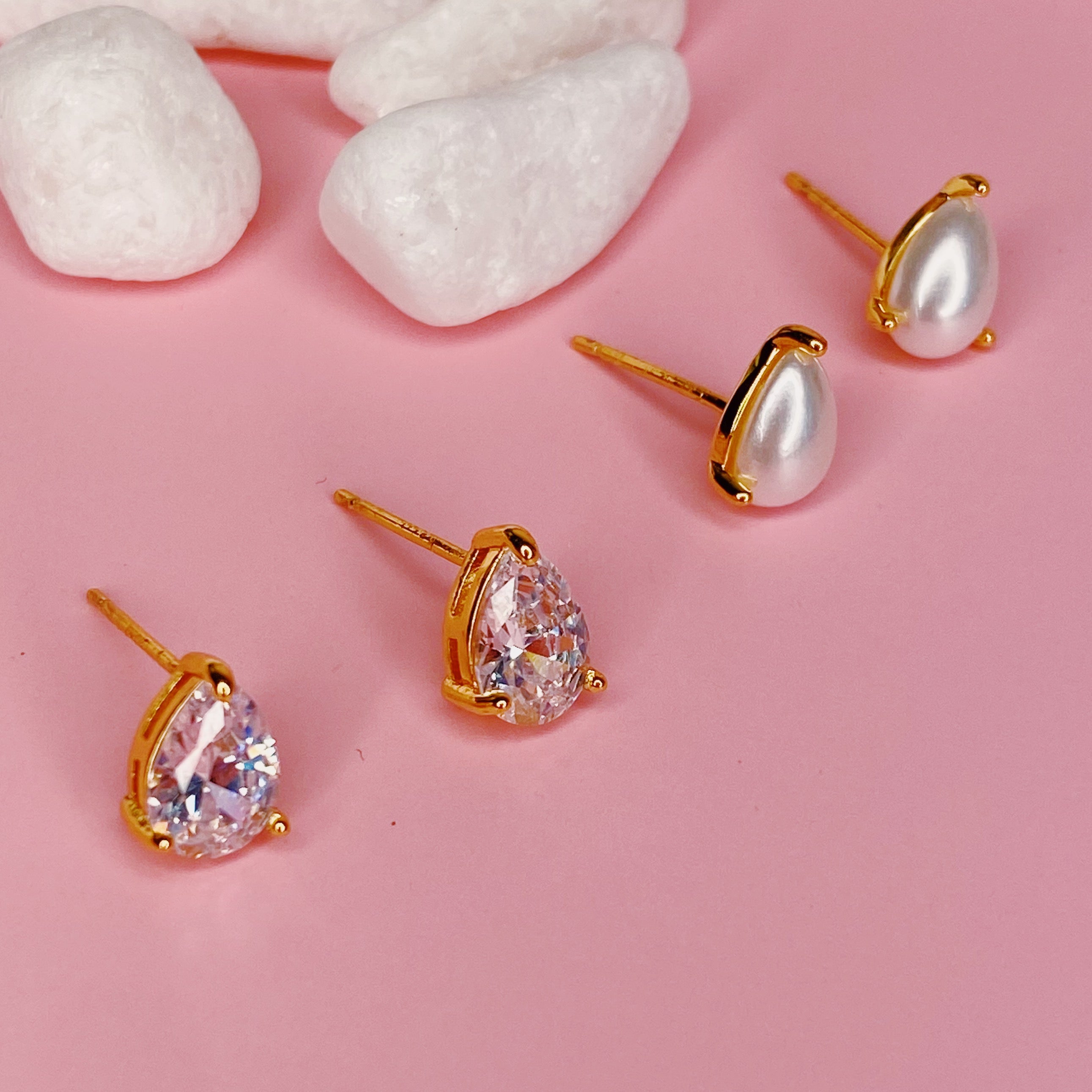 Elegant gold plated teardrop stud earrings with cubic zirconia and glass pearls, showcasing a sophisticated design.