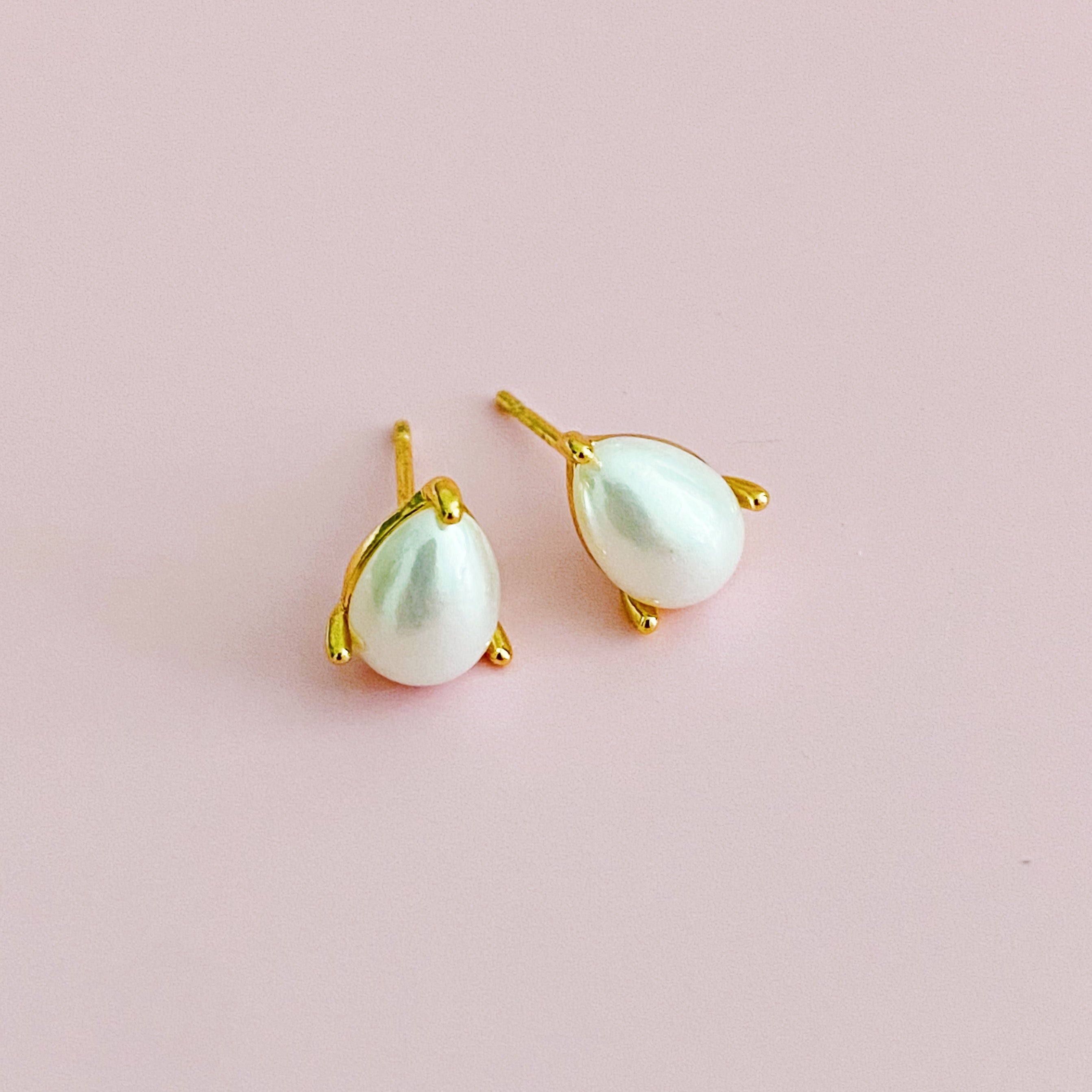 Elegant gold plated teardrop stud earrings with cubic zirconia and glass pearls, showcasing a sophisticated design.