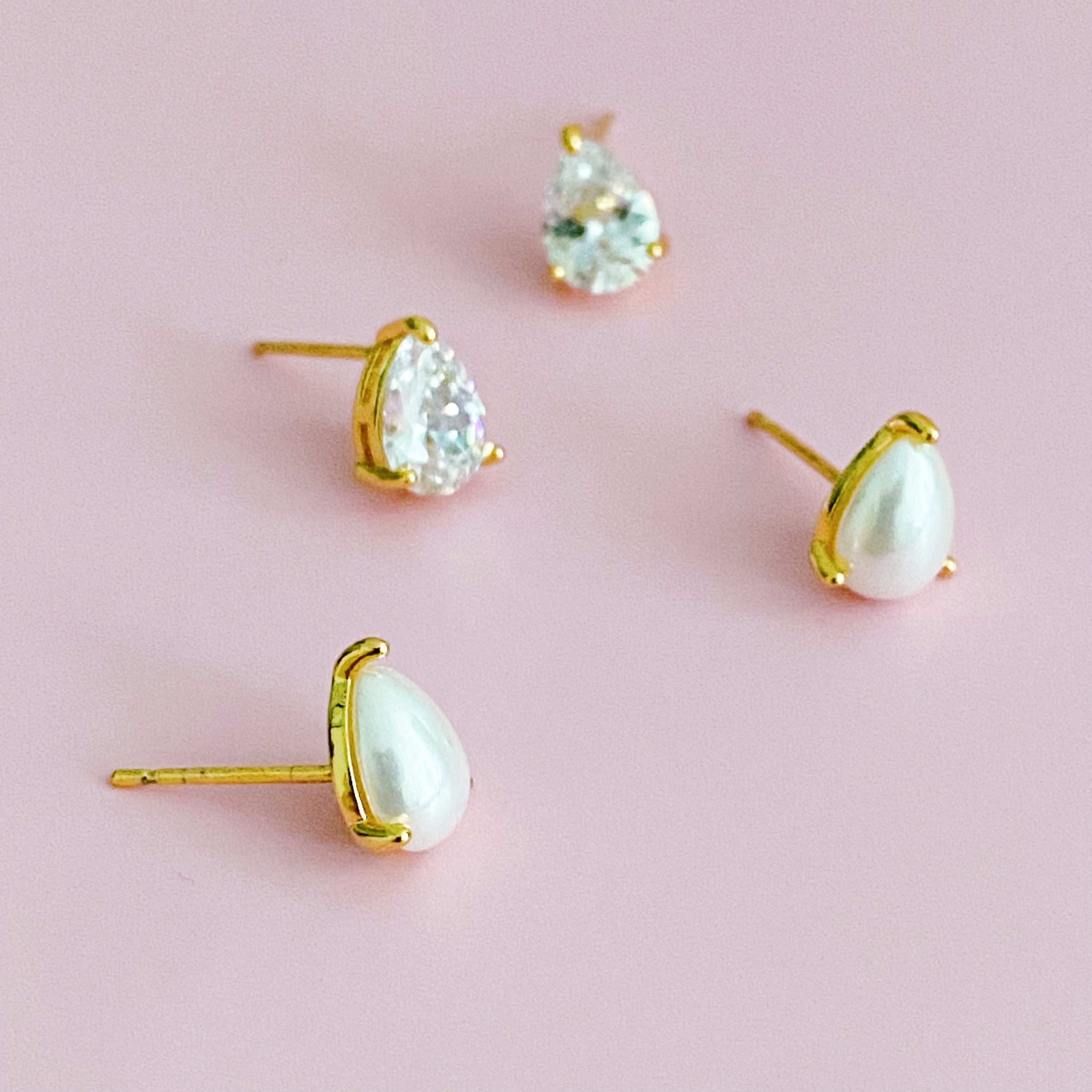 Elegant gold plated teardrop stud earrings with cubic zirconia and glass pearls, showcasing a sophisticated design.