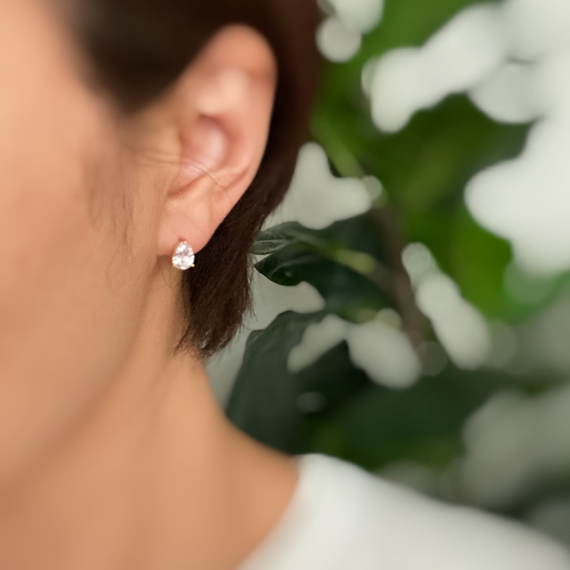 Elegant gold plated teardrop stud earrings with cubic zirconia and glass pearls, showcasing a sophisticated design.