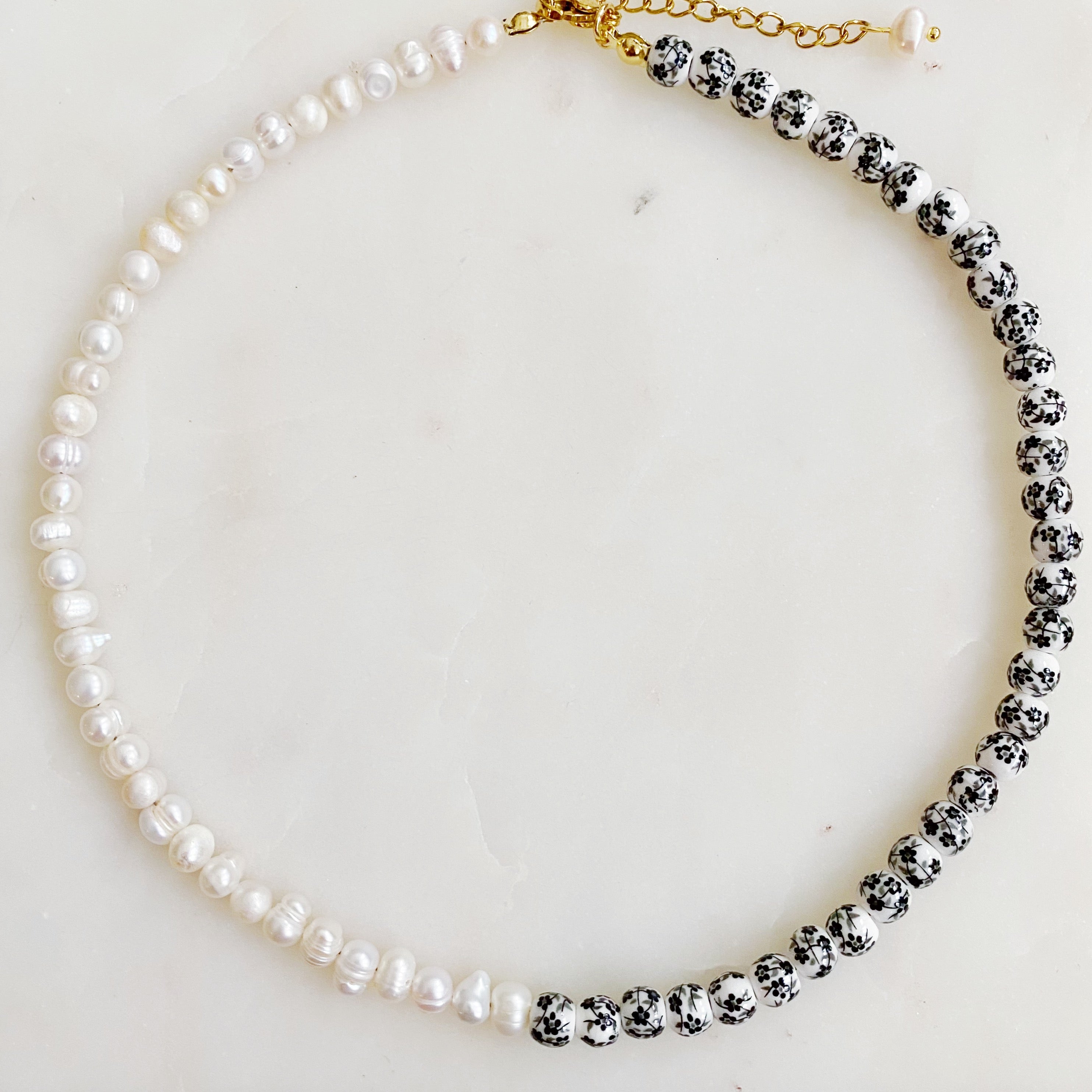 So Fresh Pearl and Porcelain Choker Necklace featuring freshwater pearls and ceramic beads, elegantly designed with gold plated stainless steel accents.