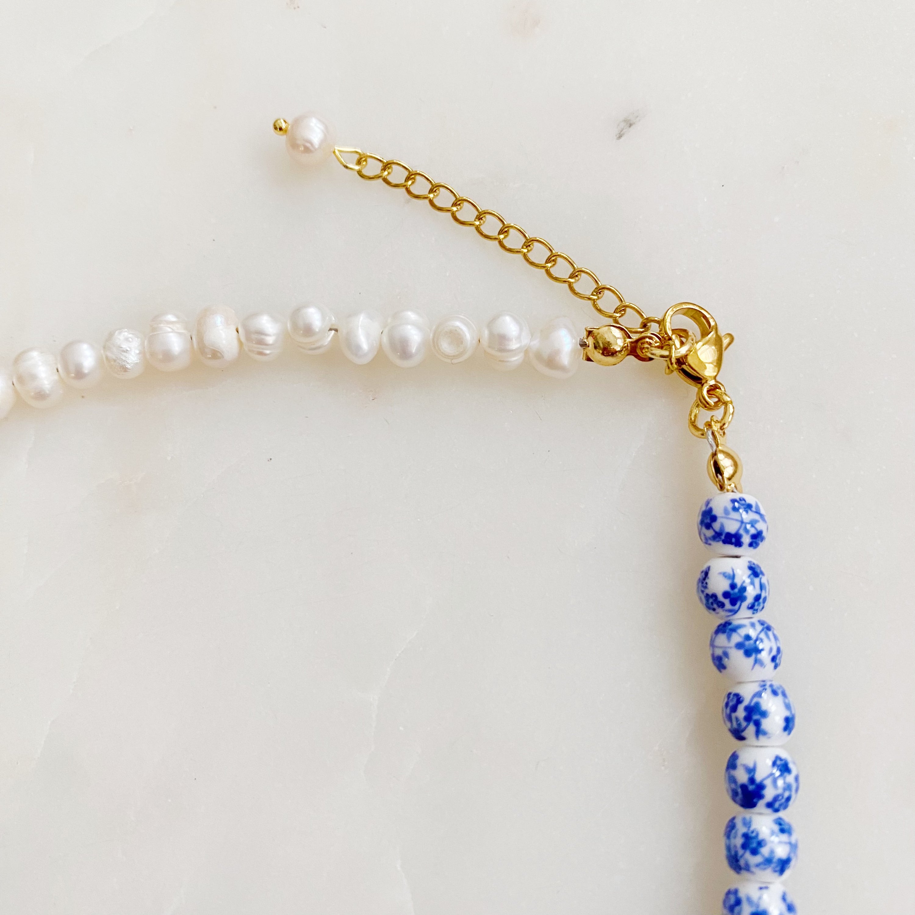 So Fresh Pearl and Porcelain Choker Necklace featuring freshwater pearls and ceramic beads, elegantly designed with gold plated stainless steel accents.