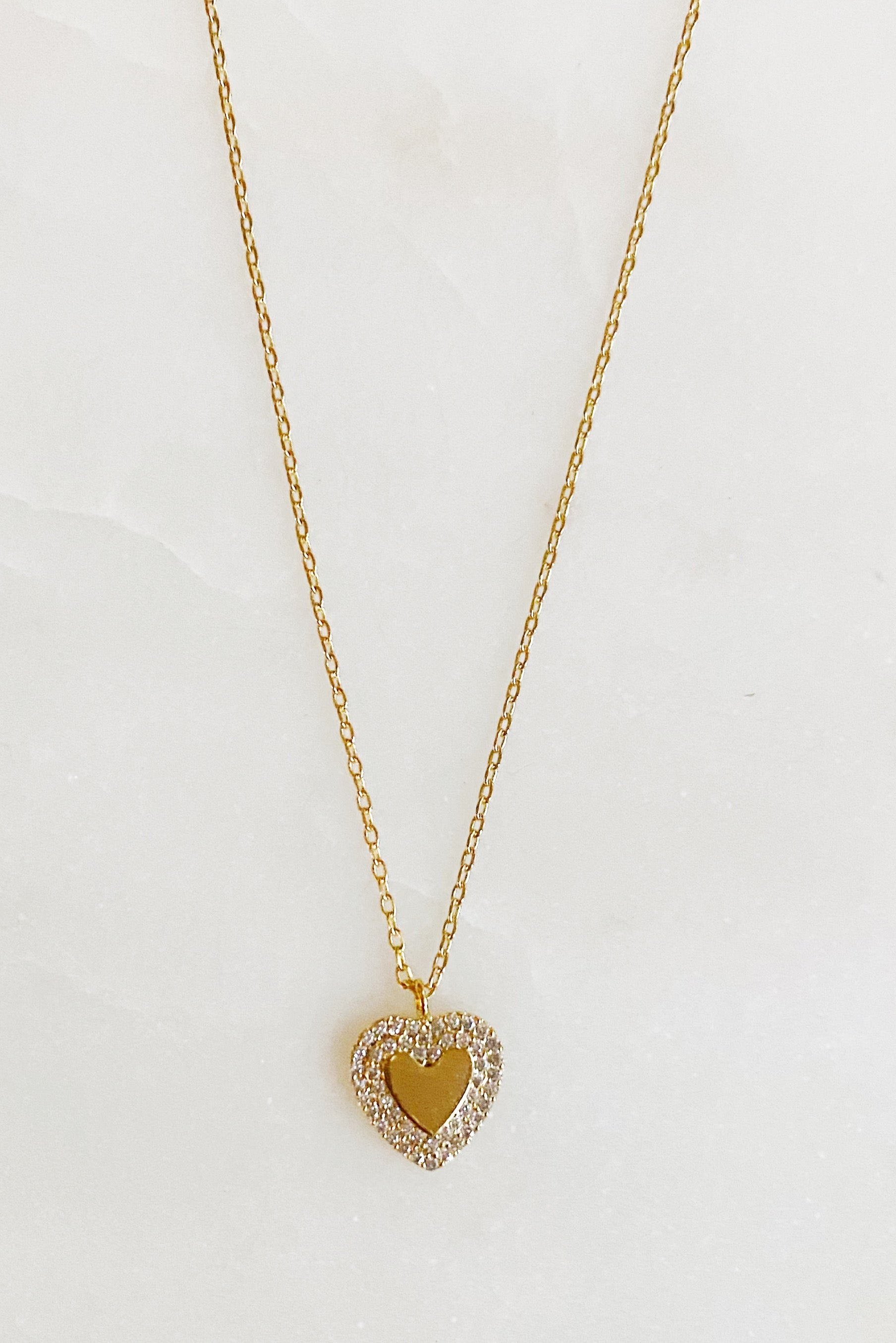 A delicate gold plated brass mini heart necklace with a 16-inch chain and a 2-inch extender, perfect for everyday wear.