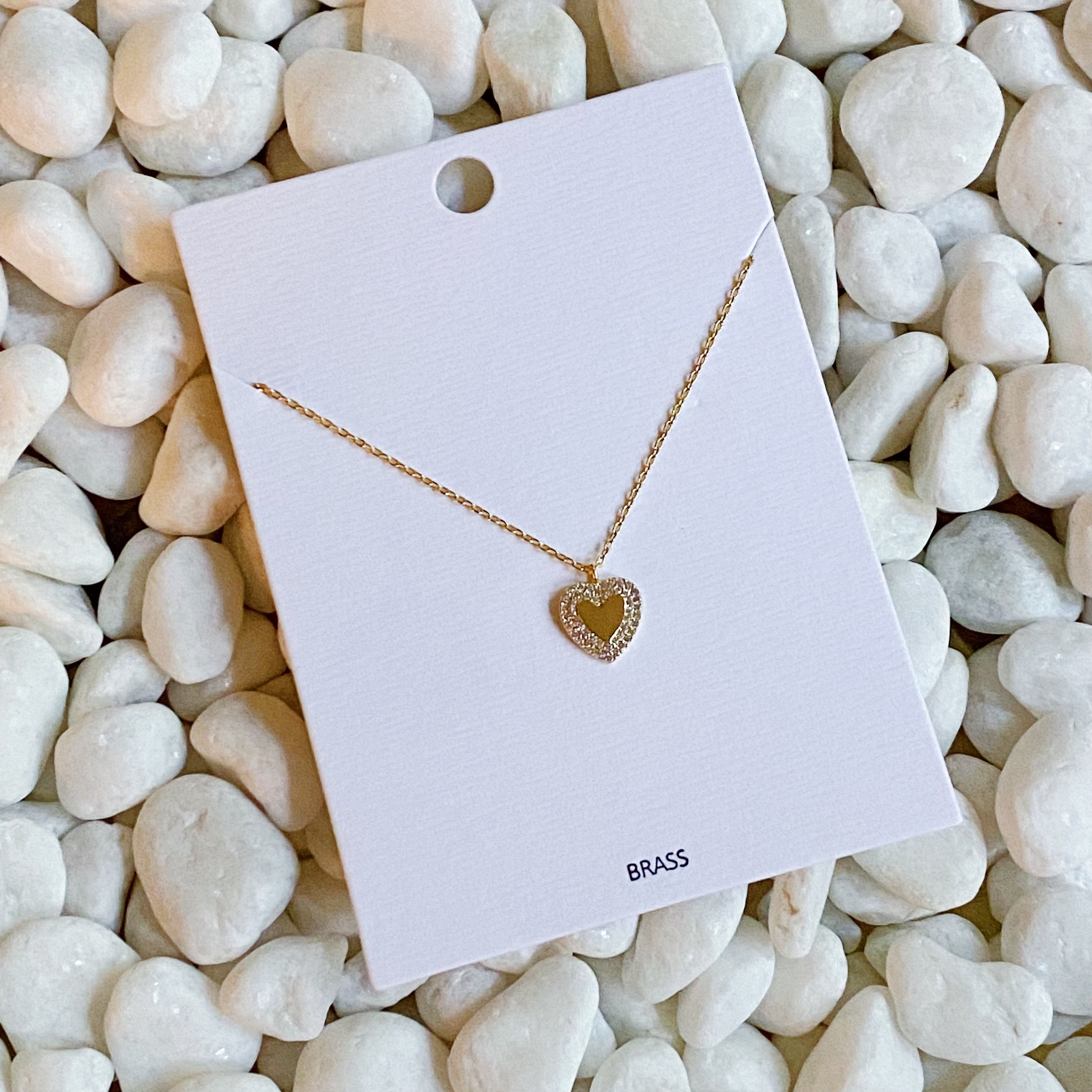 A delicate gold plated brass mini heart necklace with a 16-inch chain and a 2-inch extender, perfect for everyday wear.