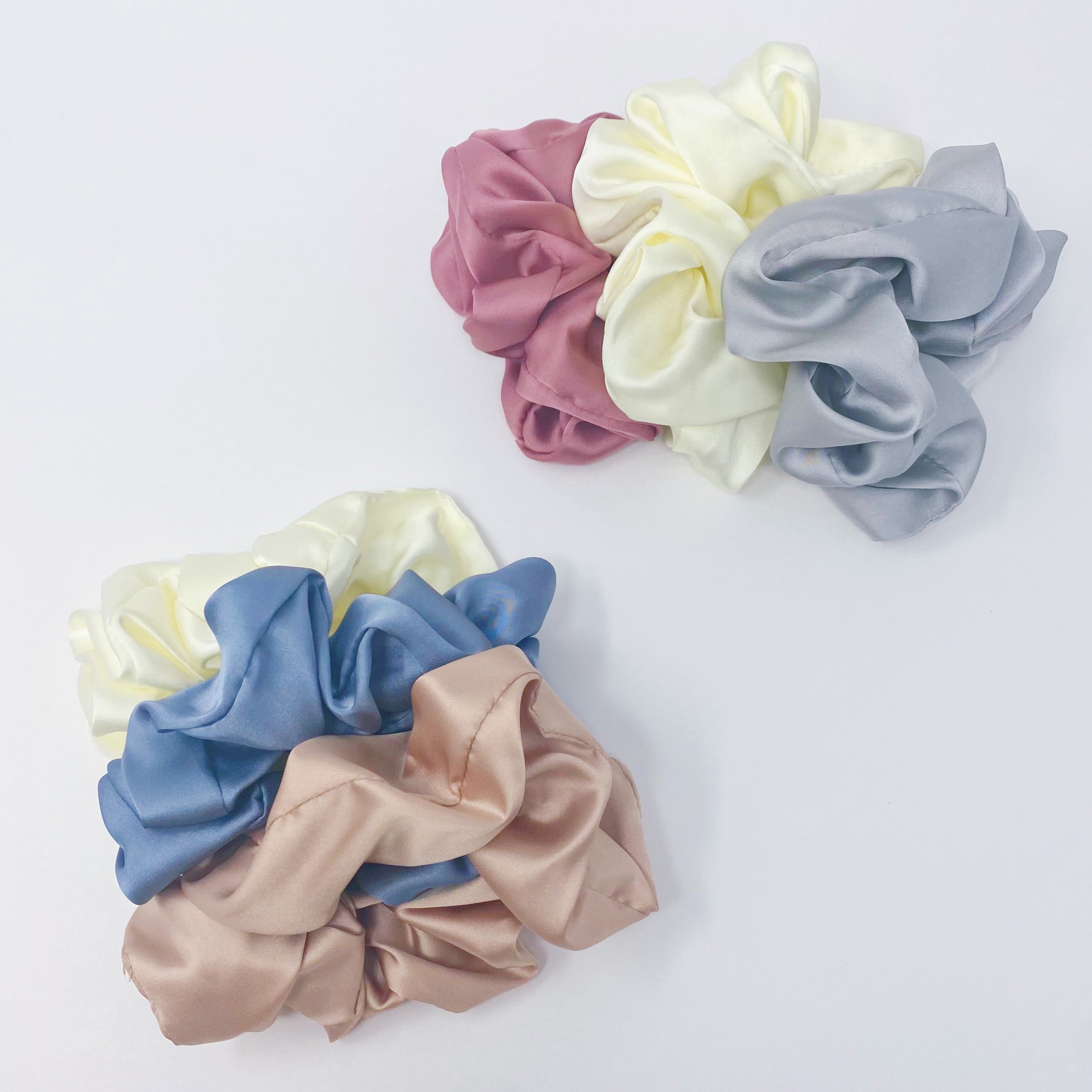 Set of 3 soft satin scrunchies in various colors, elegantly packaged in a clear cello case with Ellison + Young branding.