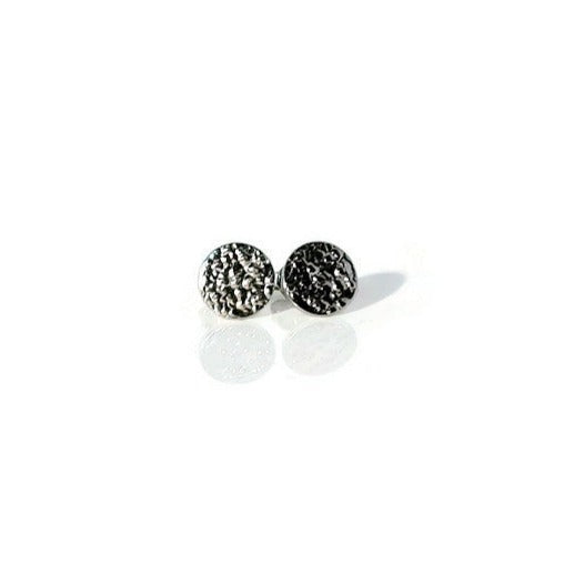 A pair of small textured circle stud earrings made of 925 sterling silver, showcasing their sparkling design and available finishes.