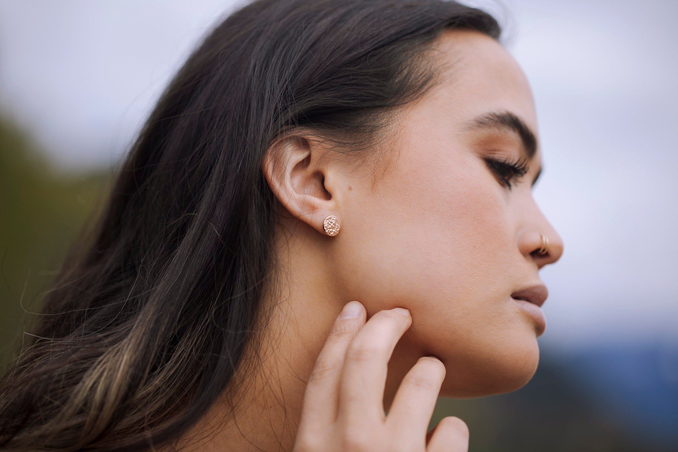 A pair of small textured circle stud earrings made of 925 sterling silver, showcasing their sparkling design and available finishes.