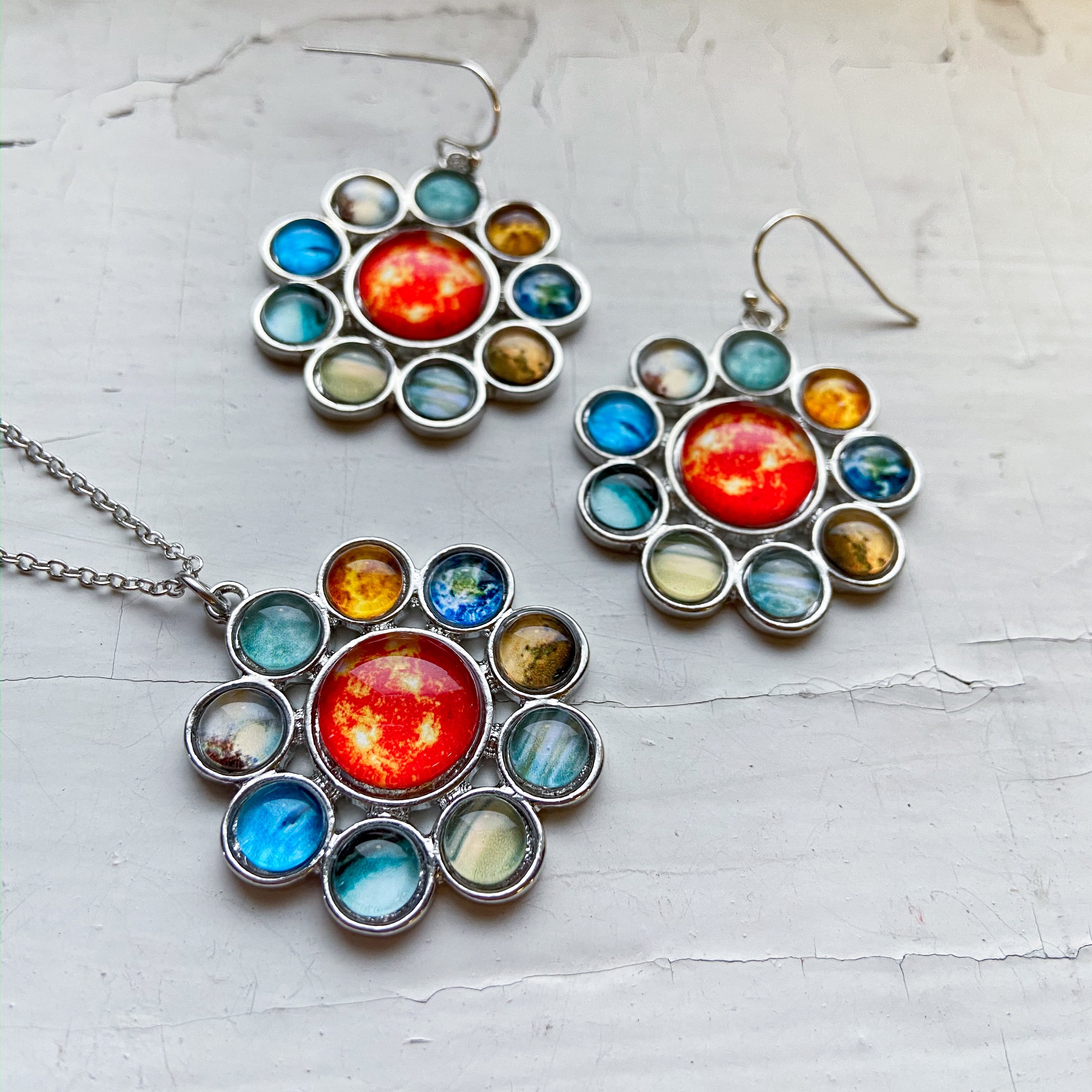 Solar System Halo Jewelry Set featuring a colorful pendant and earrings with planets and the Sun, handcrafted from rhodium plated brass and glass.