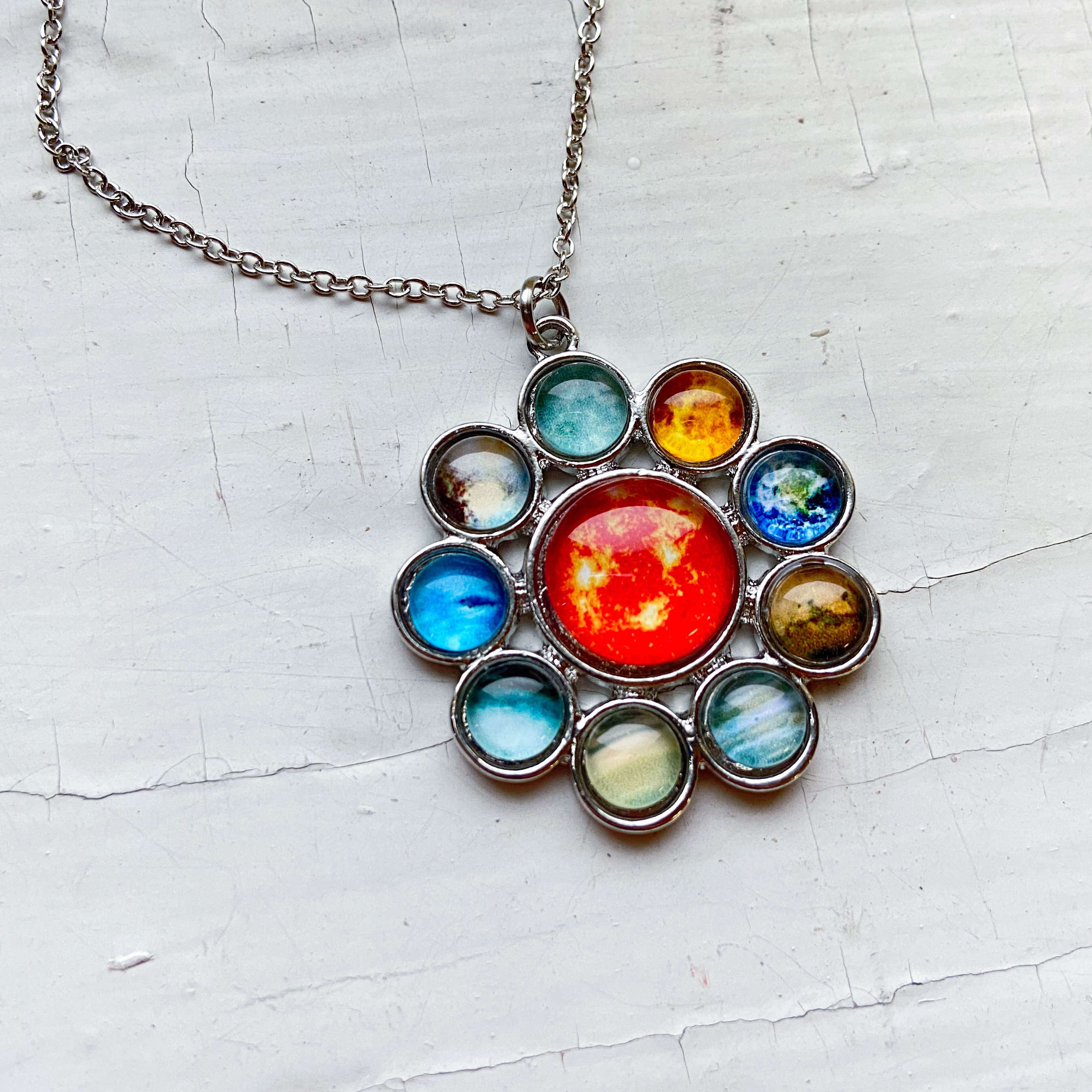 Solar System Halo Jewelry Set featuring a colorful pendant and earrings with planets and the Sun, handcrafted from rhodium plated brass and glass.