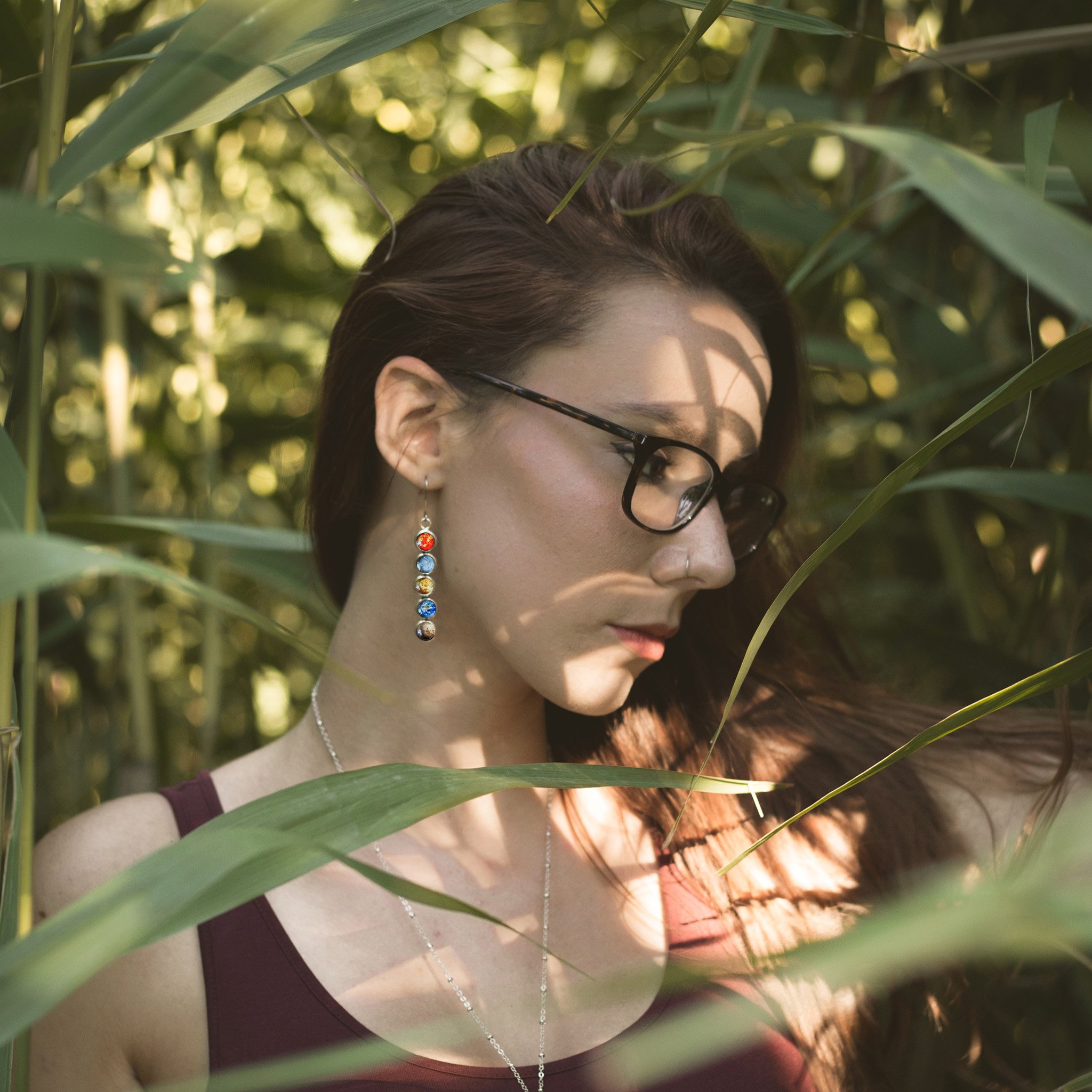 Colorful Solar System Mis-Matched Earrings featuring planets and the Sun in silver-tone bezels, hanging from French hooks.