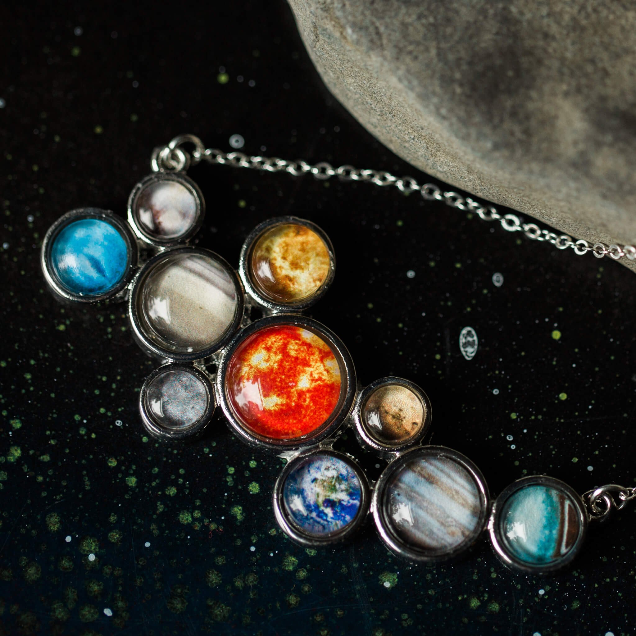 A stunning silver-tone bib necklace featuring a cosmic cluster of the Solar System, including the Sun and all planets, handcrafted with vibrant colors.