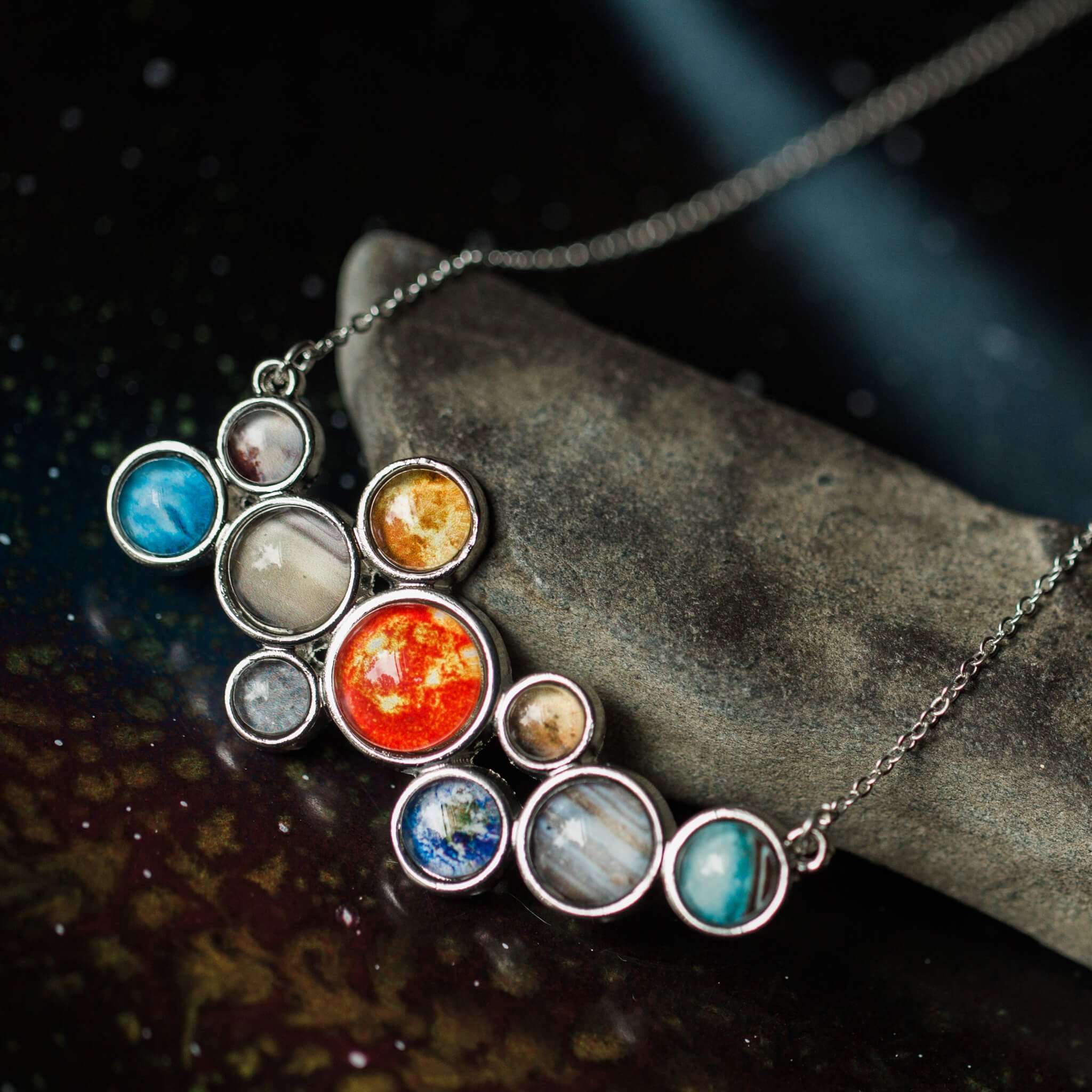 A stunning silver-tone bib necklace featuring a cosmic cluster of the Solar System, including the Sun and all planets, handcrafted with vibrant colors.