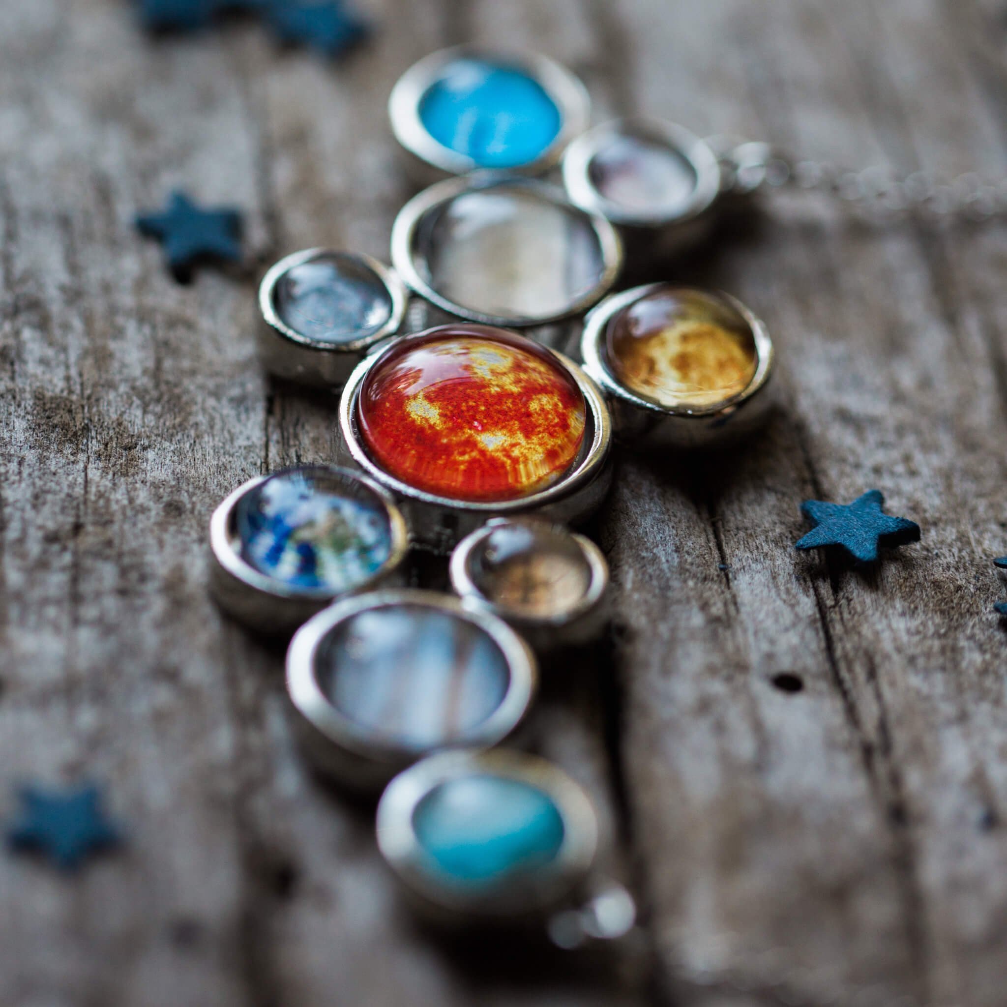 A stunning silver-tone bib necklace featuring a cosmic cluster of the Solar System, including the Sun and all planets, handcrafted with vibrant colors.