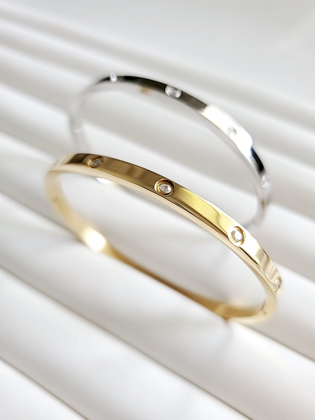 Solid Statement Bangle made of 316L Stainless Steel with 18K Gold plating and simulated diamonds, showcasing an elegant oval shape.