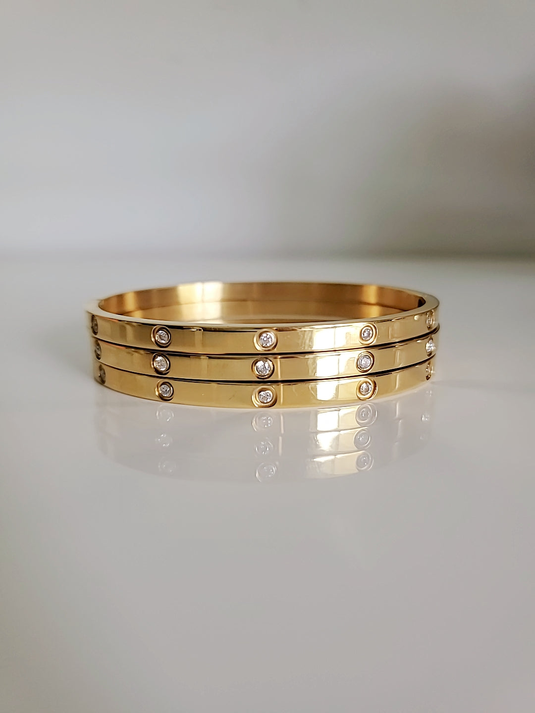 Solid Statement Bangle made of 316L Stainless Steel with 18K Gold plating and simulated diamonds, showcasing an elegant oval shape.