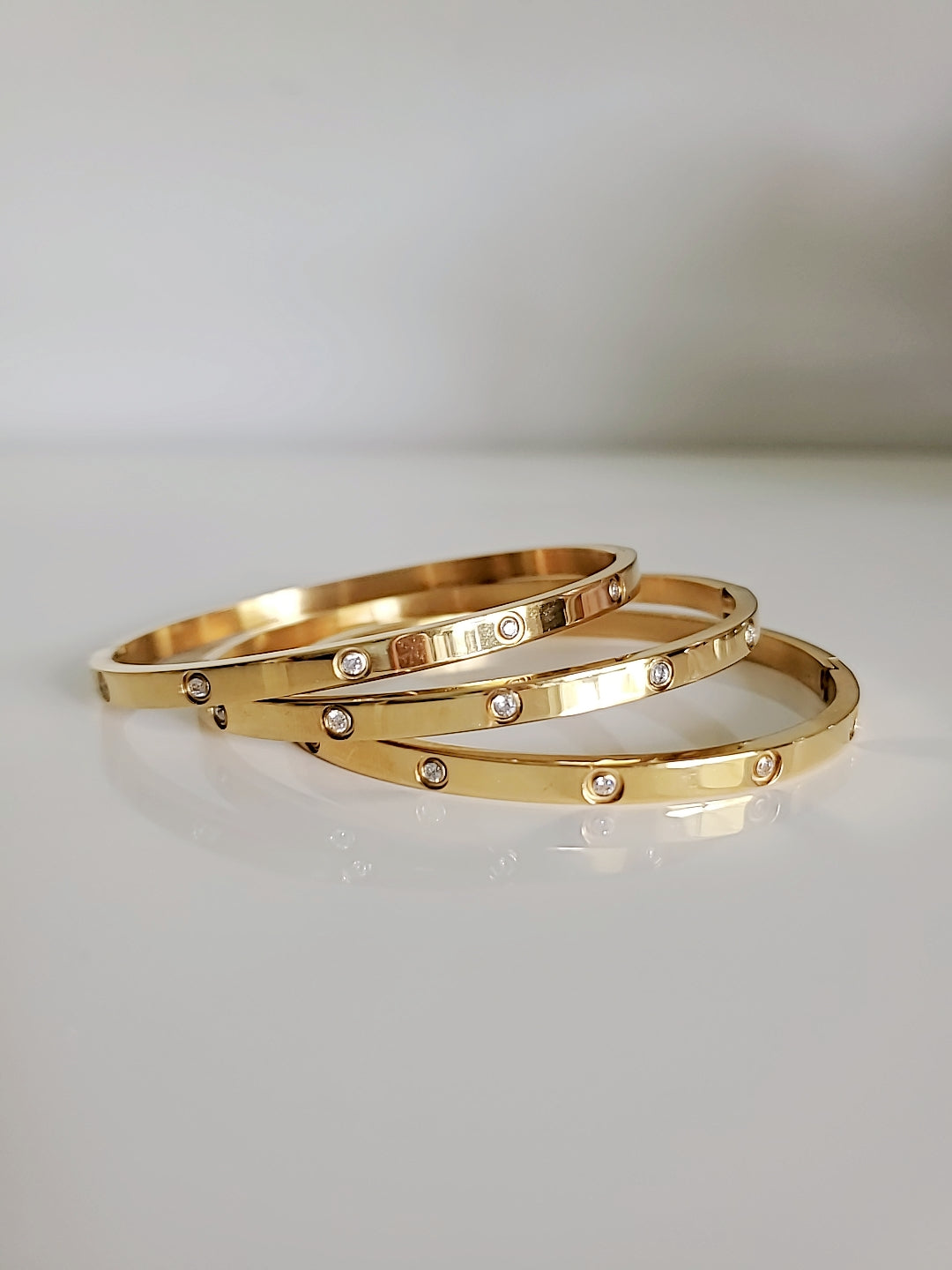 Solid Statement Bangle made of 316L Stainless Steel with 18K Gold plating and simulated diamonds, showcasing an elegant oval shape.