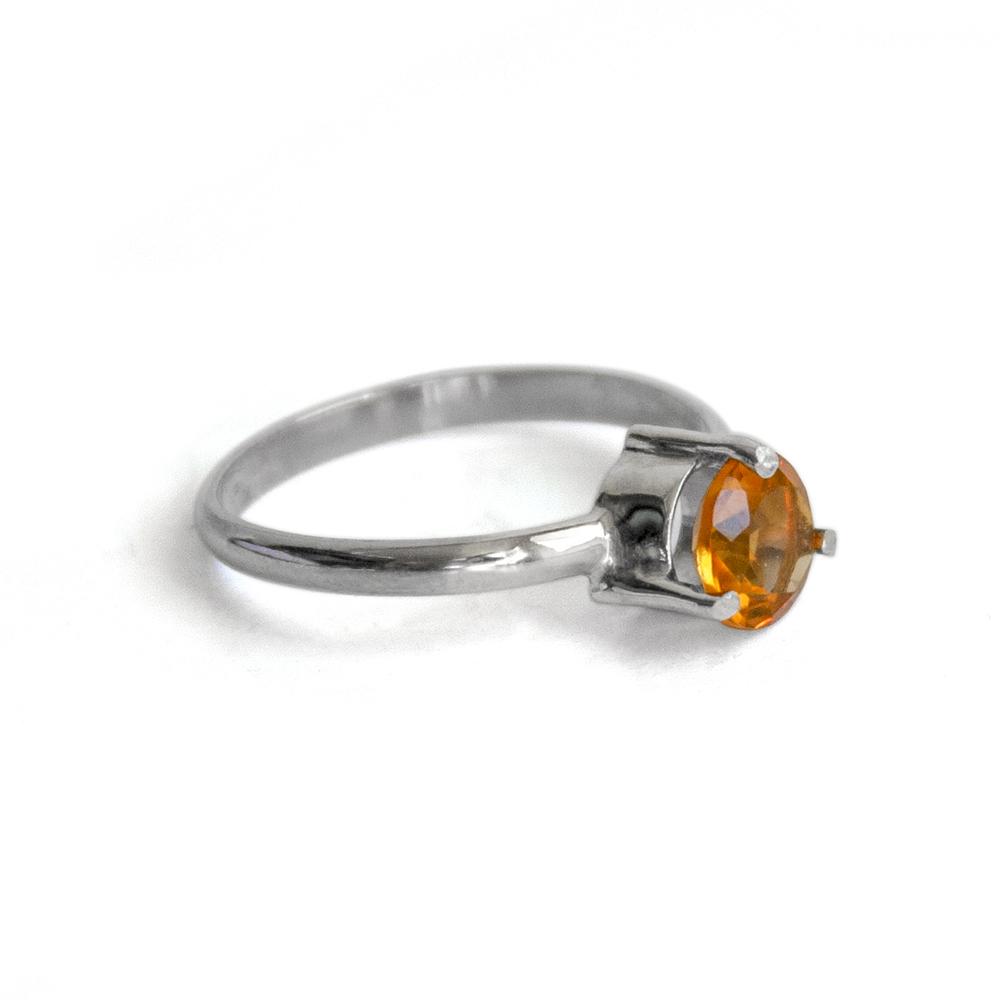 A stunning solitaire citrine ring featuring a 6mm round brilliant citrine stone set in a three prong sterling silver band.