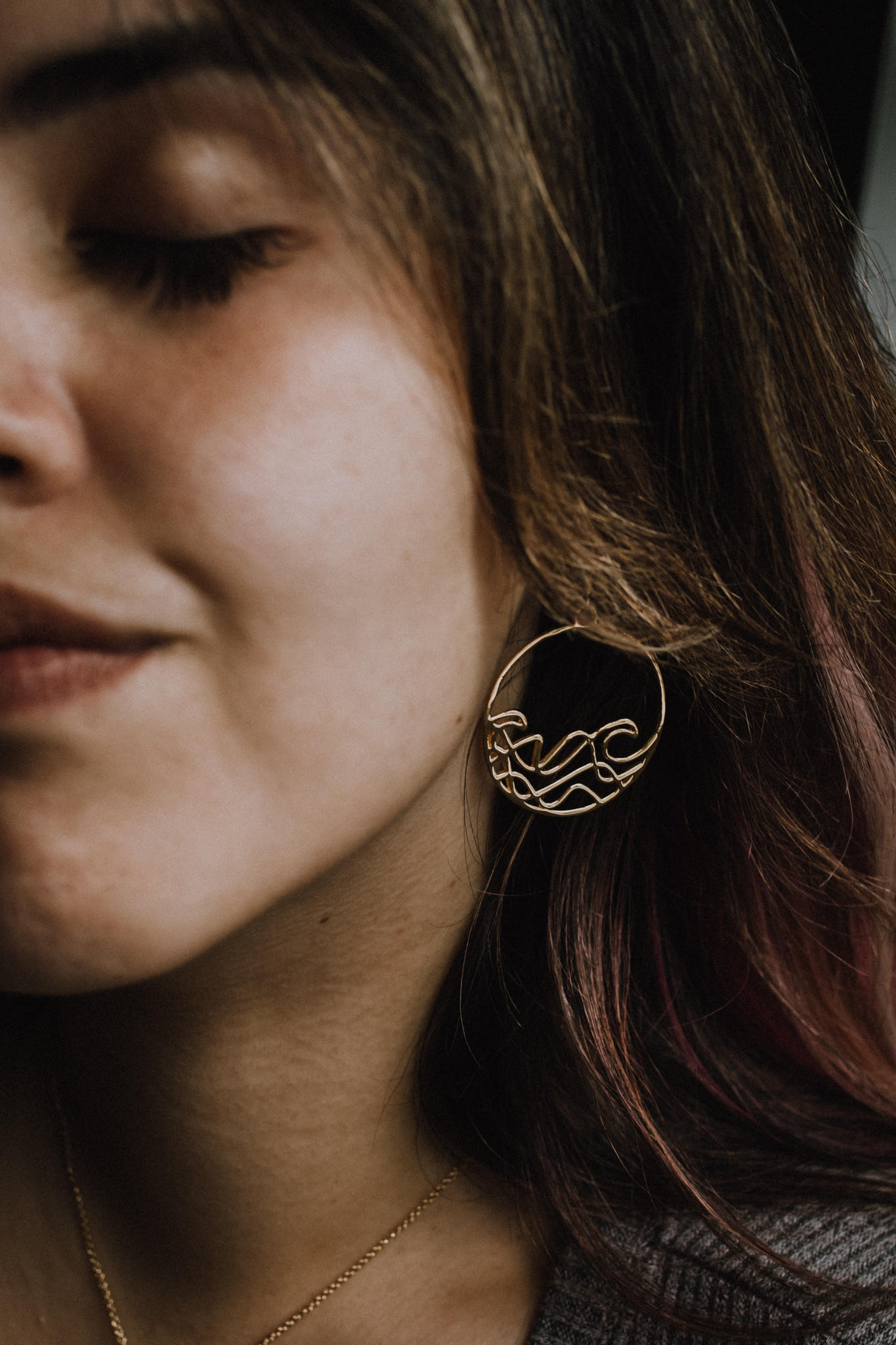 Sombrio Circle Surf Wave Earrings in sterling silver with wave design, showcasing their elegant circular shape and available plating options.