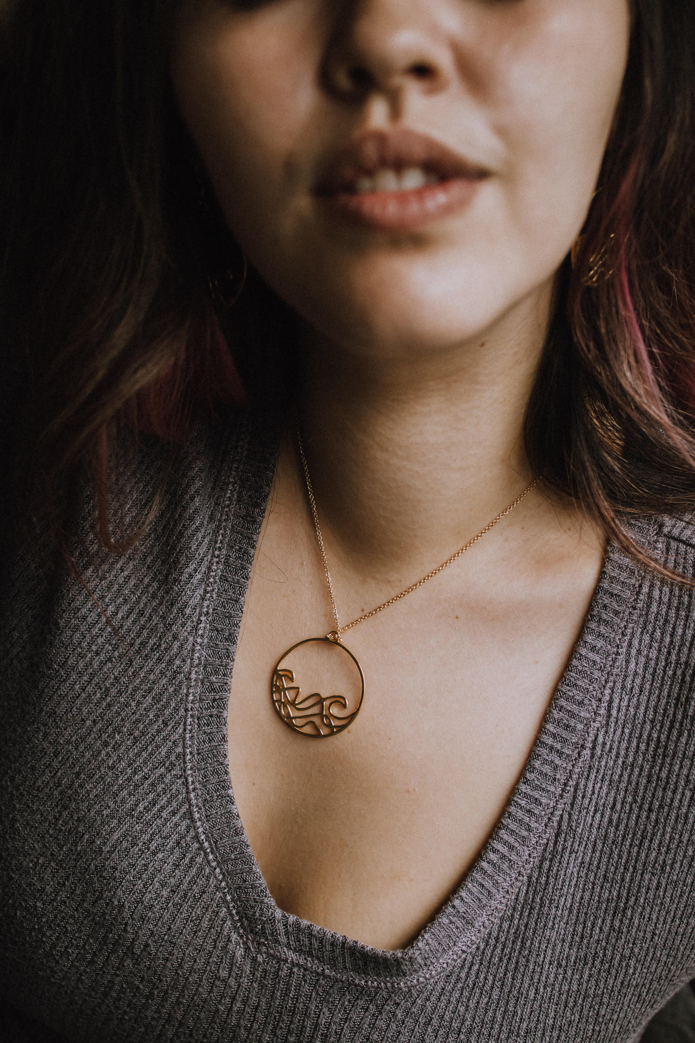 Sombrio Circle Surf Wave Necklace featuring a 925 sterling silver pendant with a wave design on a sterling silver cable chain.