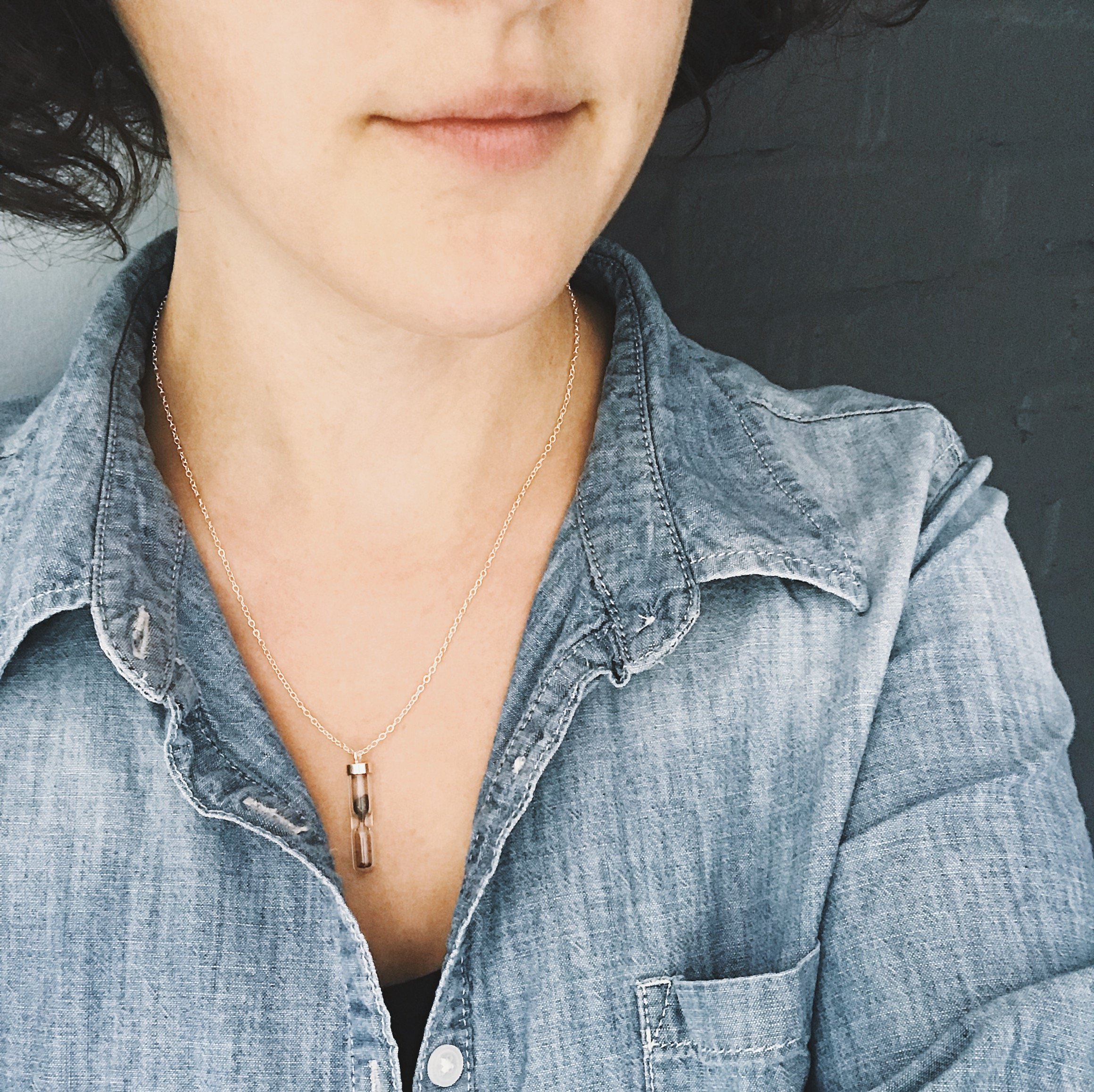 Space Time Hourglass Necklace featuring a clear pendant with authentic meteorite dust, elegantly designed with a sterling silver chain.