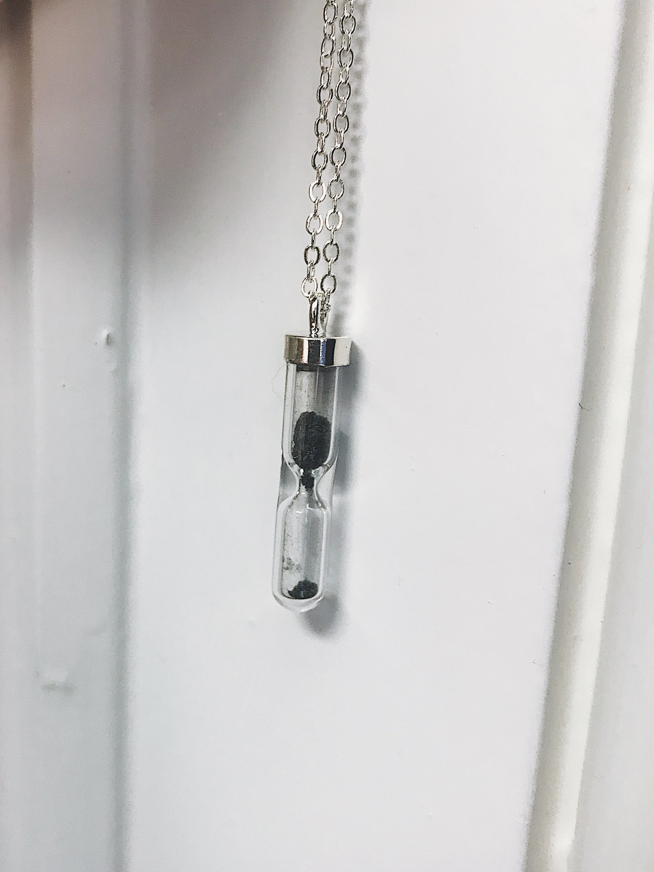 Space Time Hourglass Necklace featuring a clear pendant with authentic meteorite dust, elegantly designed with a sterling silver chain.