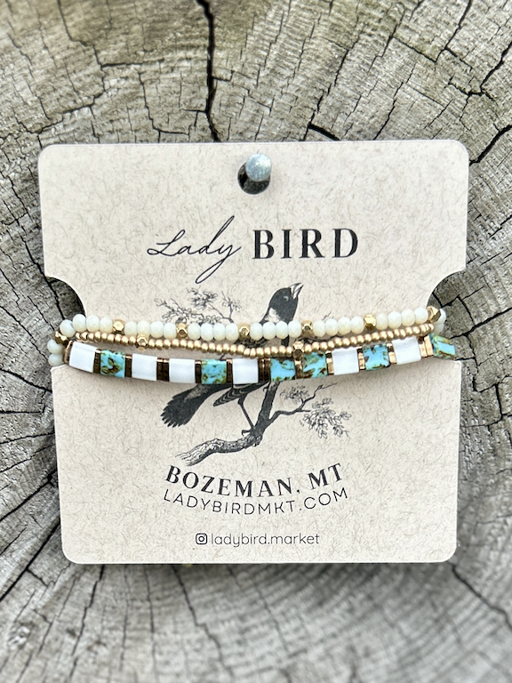 A stylish speckled turquoise bracelet featuring white and gold Tila beads, showcasing a bohemian design.