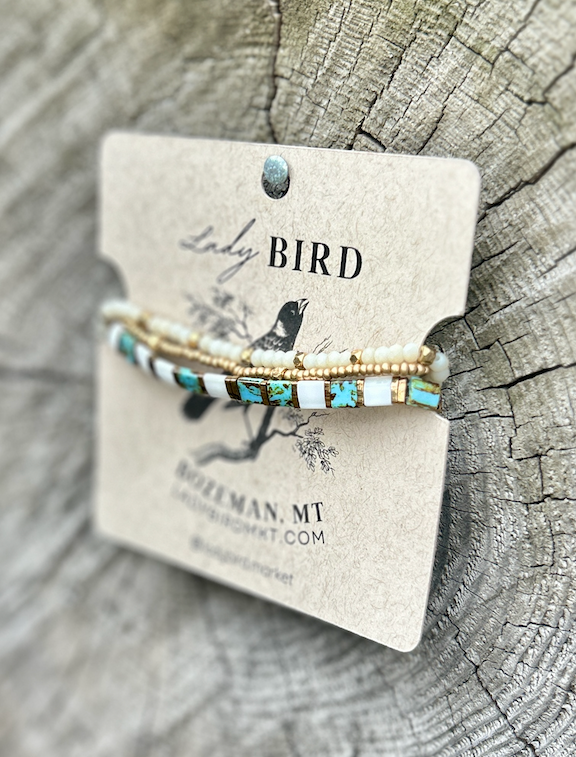 A stylish speckled turquoise bracelet featuring white and gold Tila beads, showcasing a bohemian design.