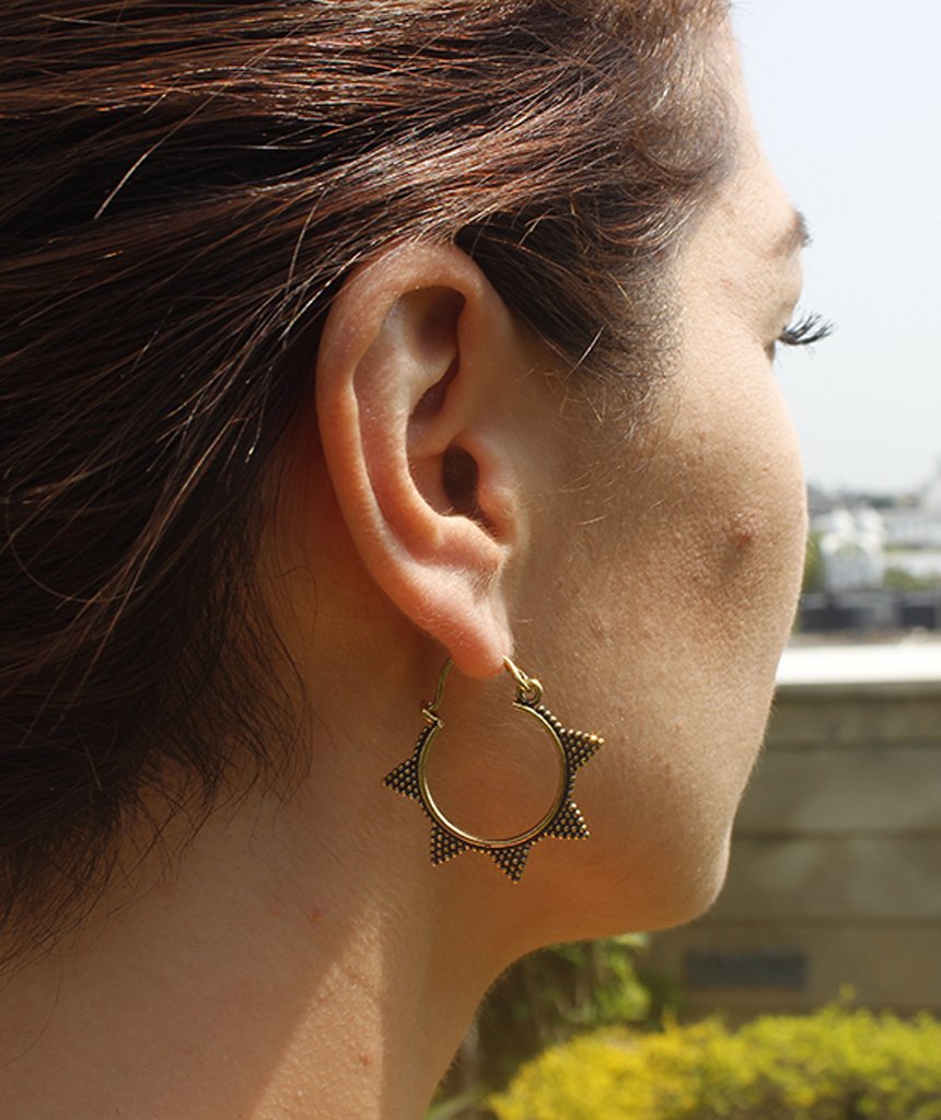 A pair of Spiked Sun Hoop Earrings featuring a circular design with spikes and a spotted pattern, crafted from hypoallergenic brass.