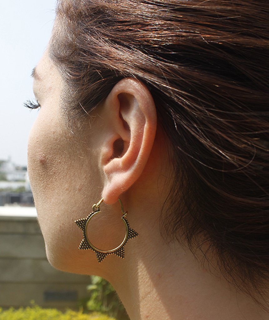 A pair of Spiked Sun Hoop Earrings featuring a circular design with spikes and a spotted pattern, crafted from hypoallergenic brass.