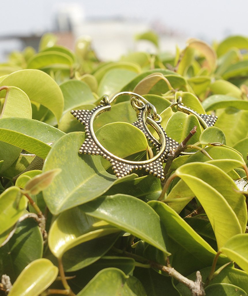 A pair of Spiked Sun Hoop Earrings featuring a circular design with spikes and a spotted pattern, crafted from hypoallergenic brass.