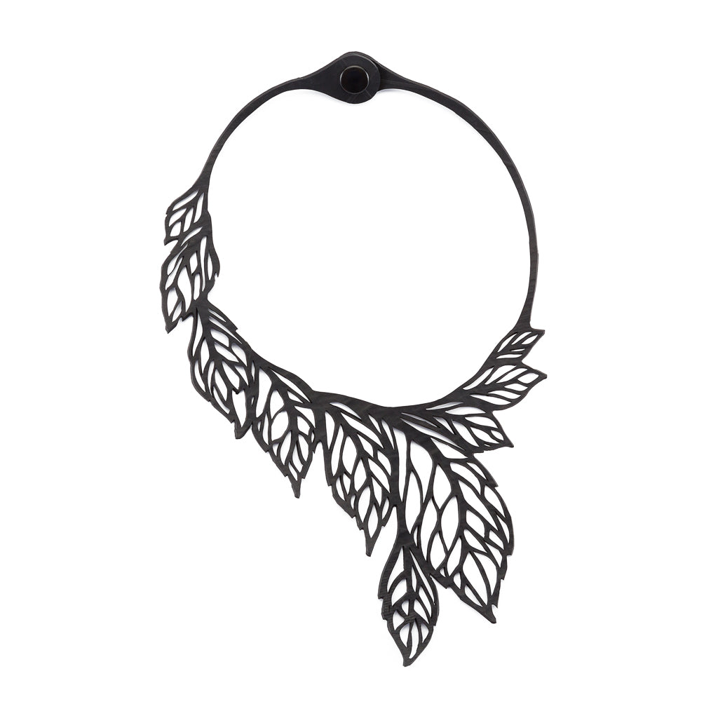 A handcrafted Spring Leaf Recycled Rubber Necklace made from upcycled materials, featuring a unique design and a durable inner tube cord.