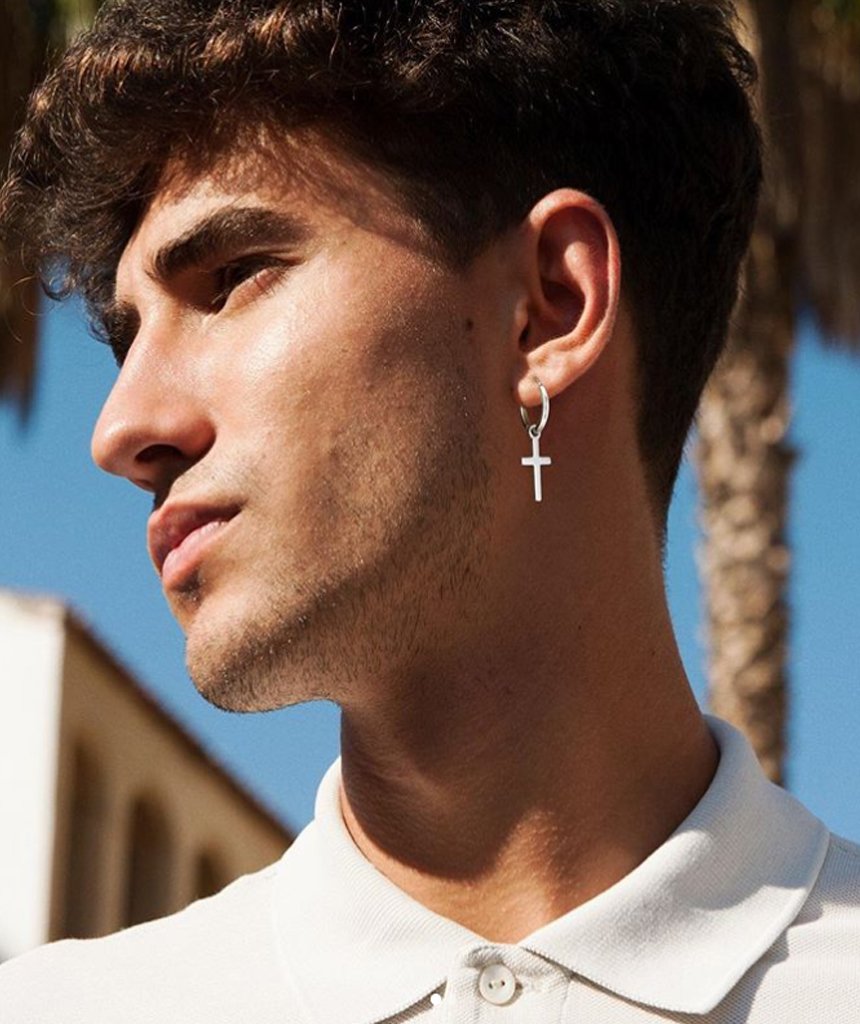 A pair of stainless steel hoop earrings featuring dangling crosses in various sizes, available in gold, silver, and black.