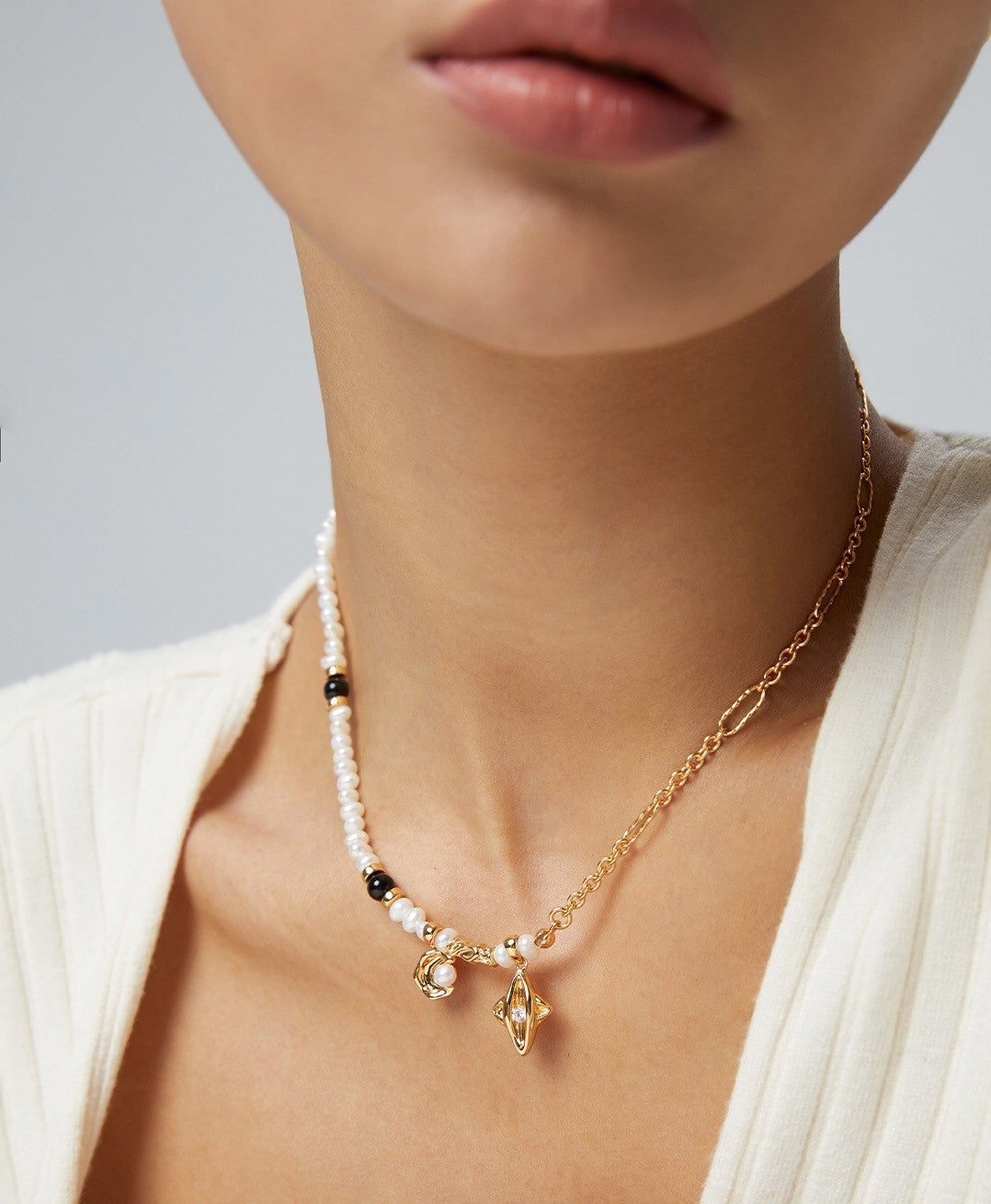 Star and Moon Design Pearl Necklace featuring natural pearls, black agate, and gold vermeil, elegantly displayed on a soft background.