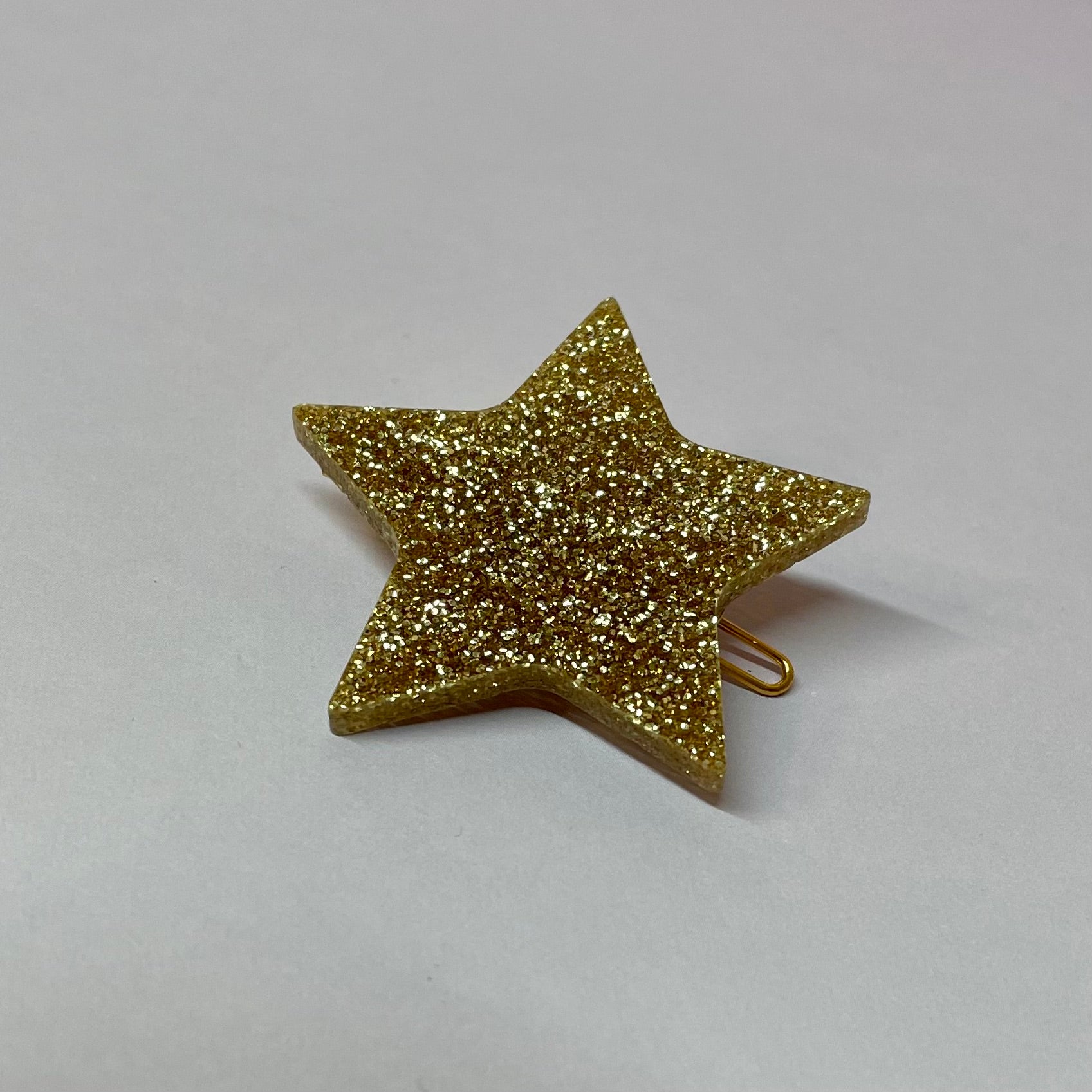 A collection of colorful star-shaped hairclips, magnets, and brooches made from laser-cut acrylic, showcasing their unique designs.