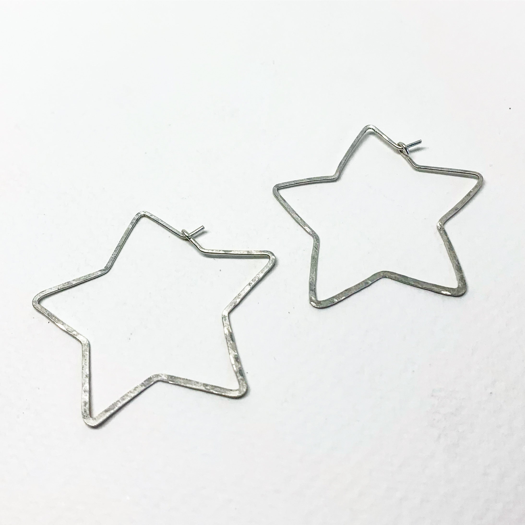 Handcrafted large star-shaped hoops made from 20 gauge wire, featuring a hammered texture and available in silver, yellow gold fill, or rose gold fill.